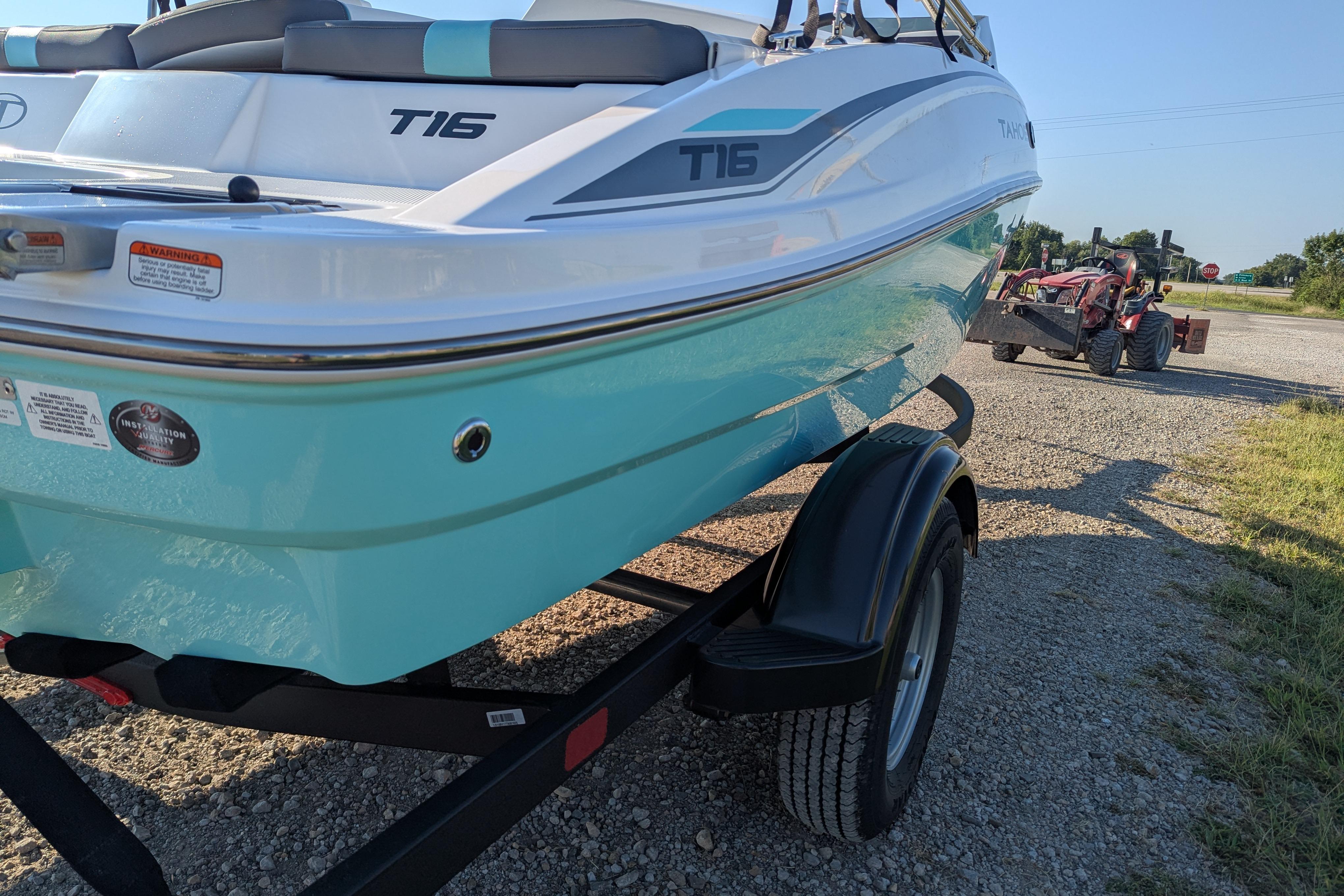 2026 Tahoe T16 boat on trailer, parked on gravel road, with tractor in background.