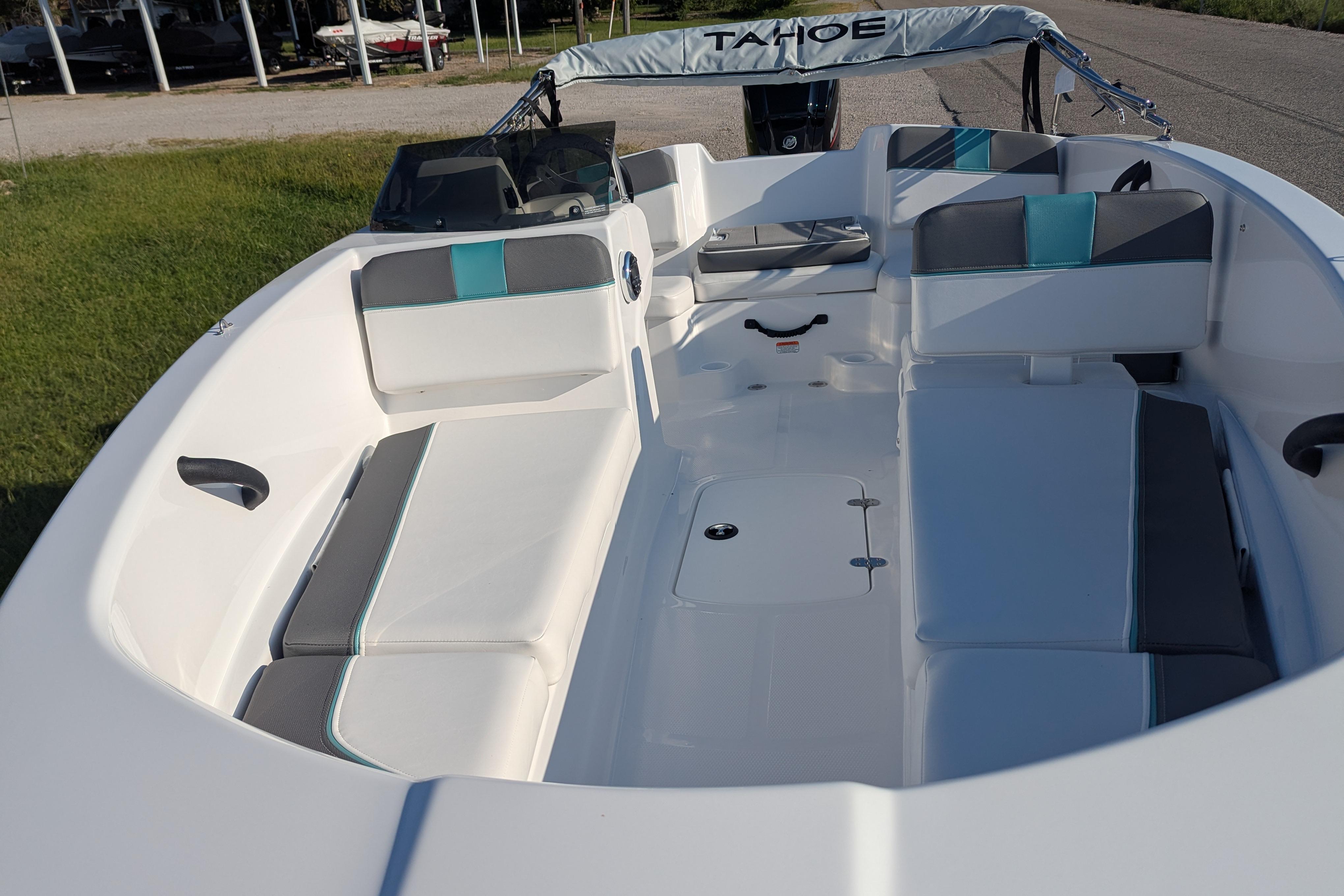 2026 Tahoe T16 boat interior with white and teal seating, parked outdoors.