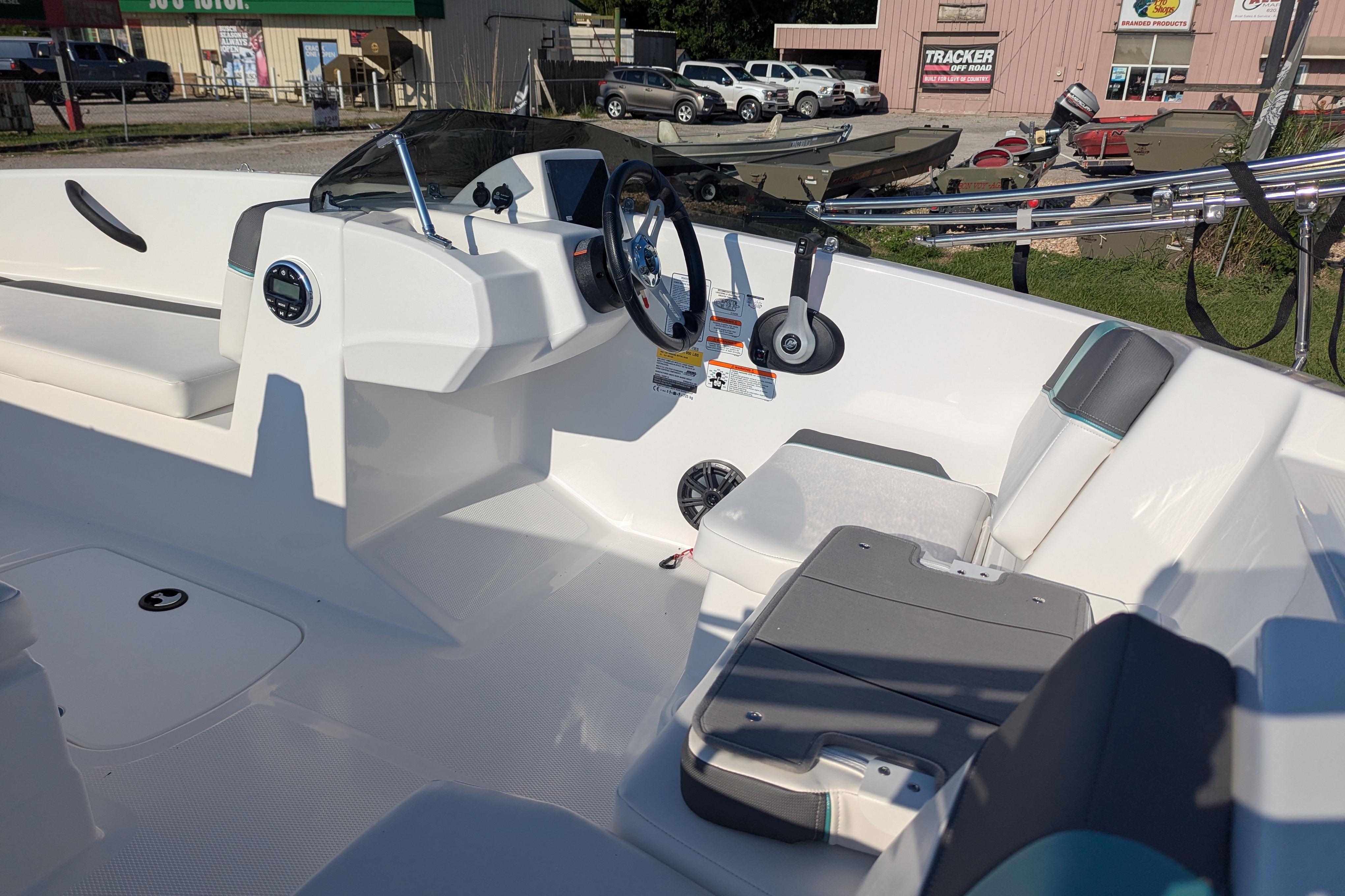 2026 Tahoe T16 boat interior with steering wheel and seating, parked outdoors.