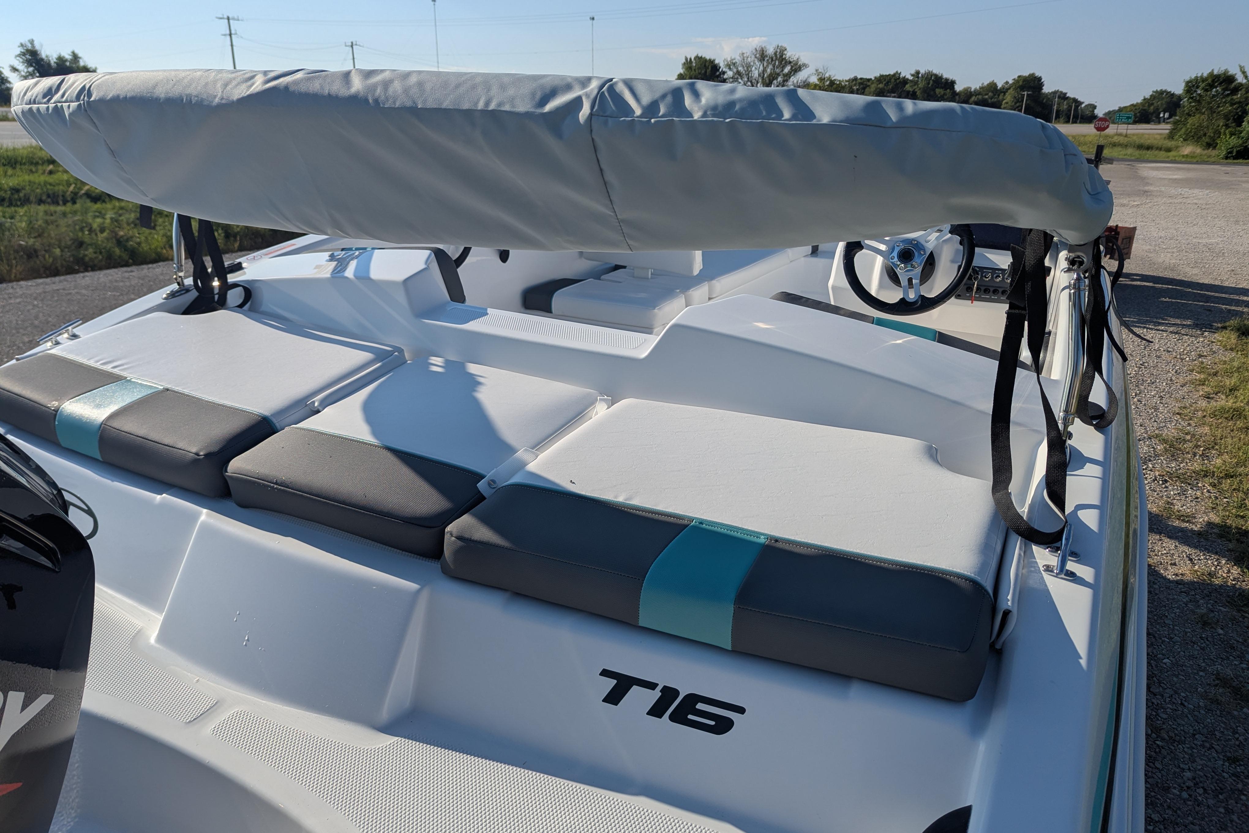 2026 Tahoe T16 boat with cushioned seating and steering wheel, parked outdoors.