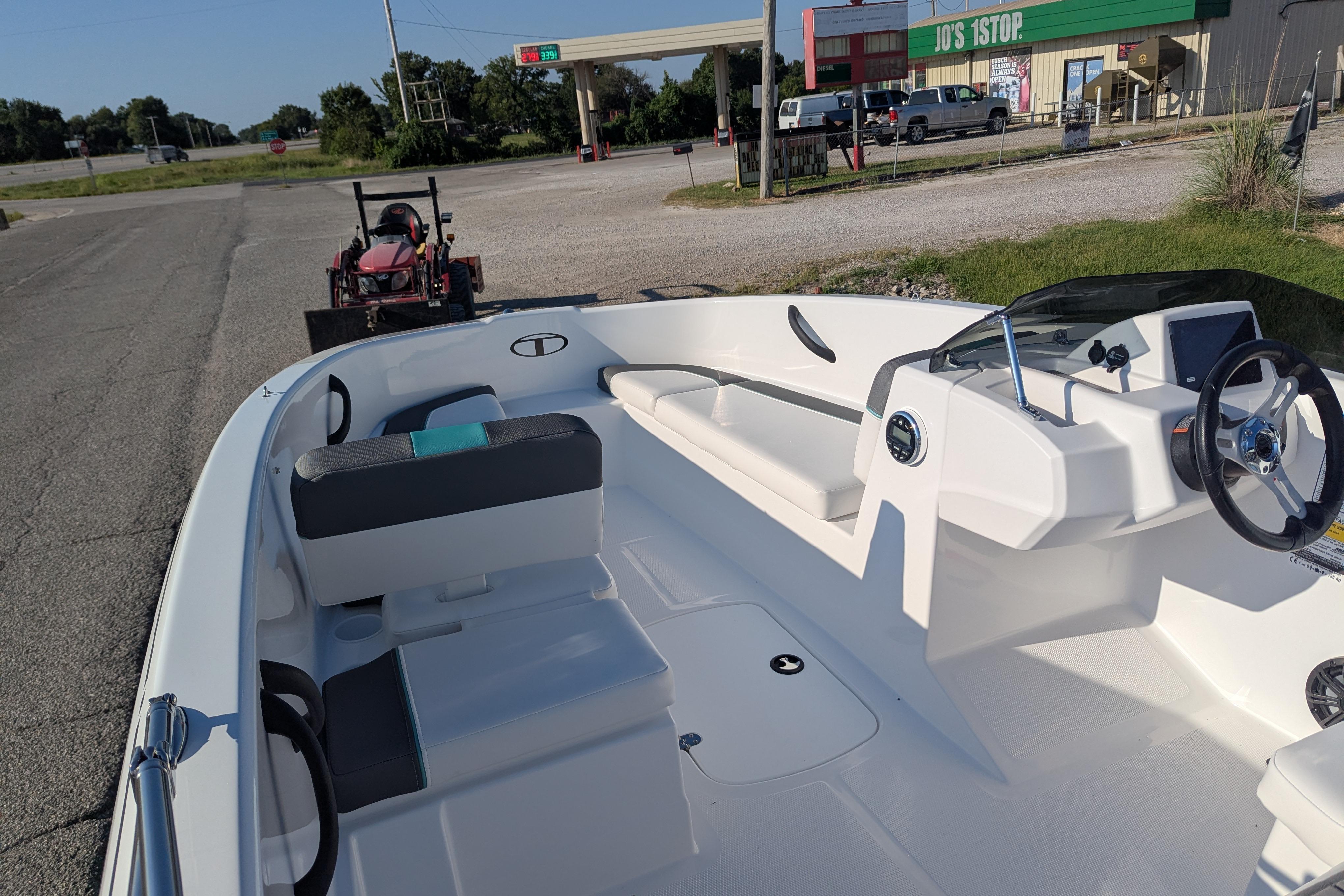 2026 Tahoe T16 boat interior at a roadside stop with a gas station in the background.
