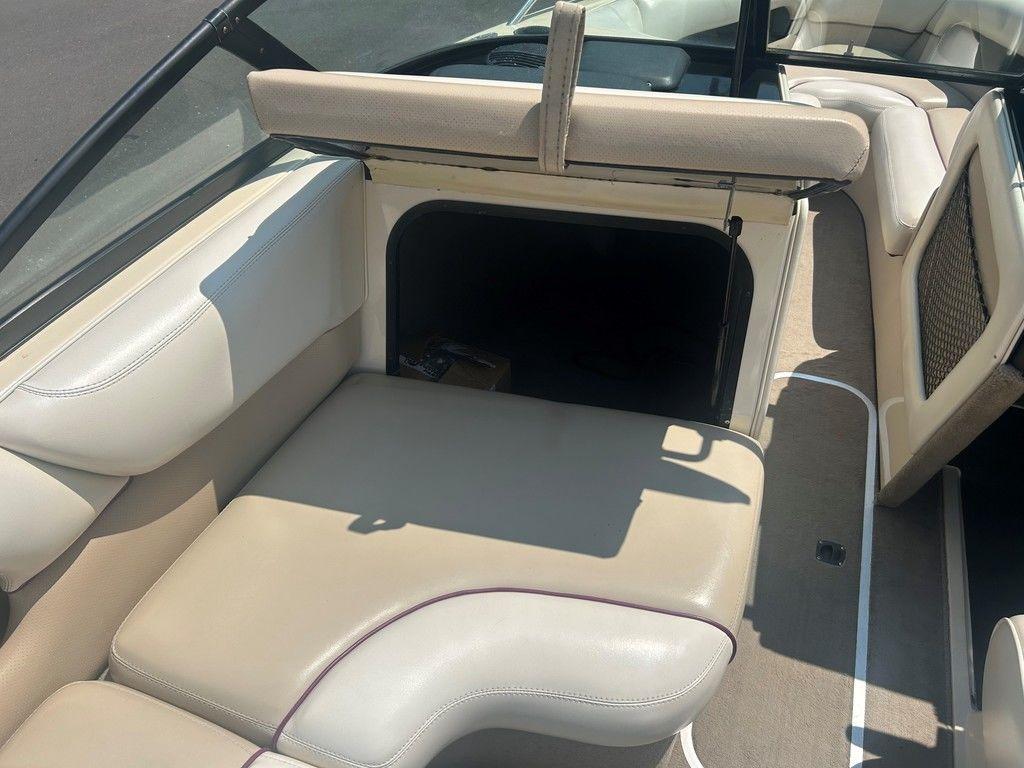 1999 Malibu Sunsetter VLX boat interior with beige seating and storage compartment.