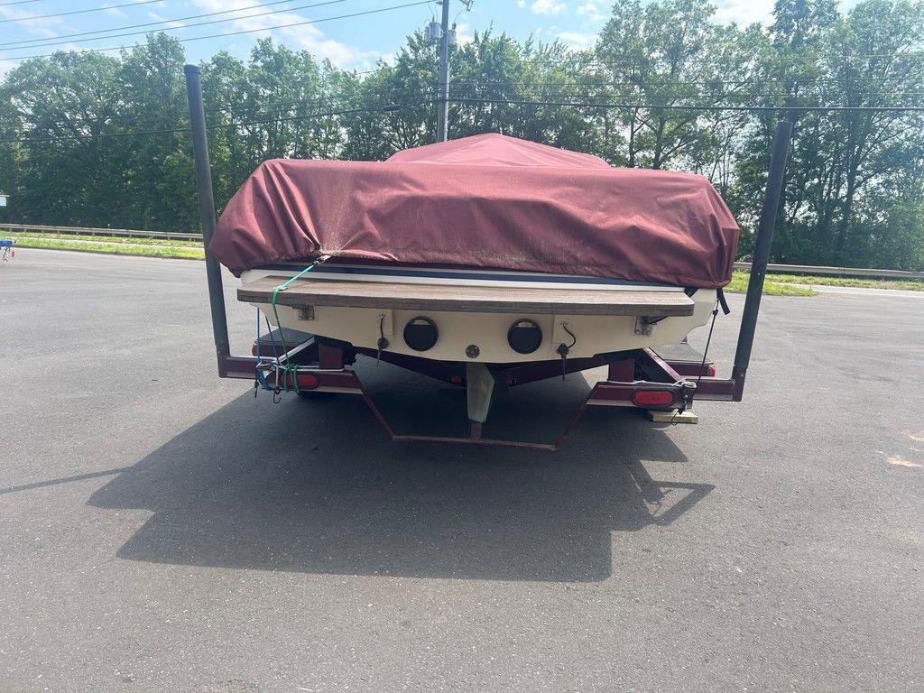 1999 Malibu Sunsetter VLX boat covered on trailer, parked outdoors.