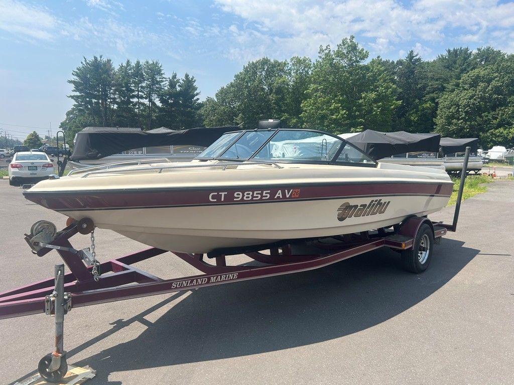 1999 Malibu Sunsetter VLX boat on trailer in sunny outdoor setting.