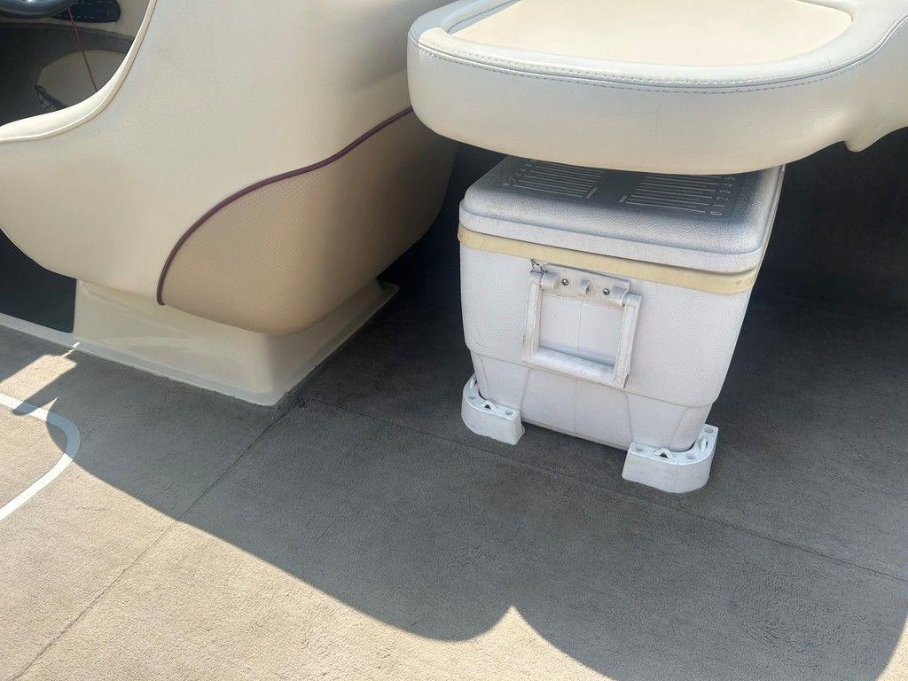 1999 Malibu Sunsetter VLX boat interior with beige seating and a white cooler.