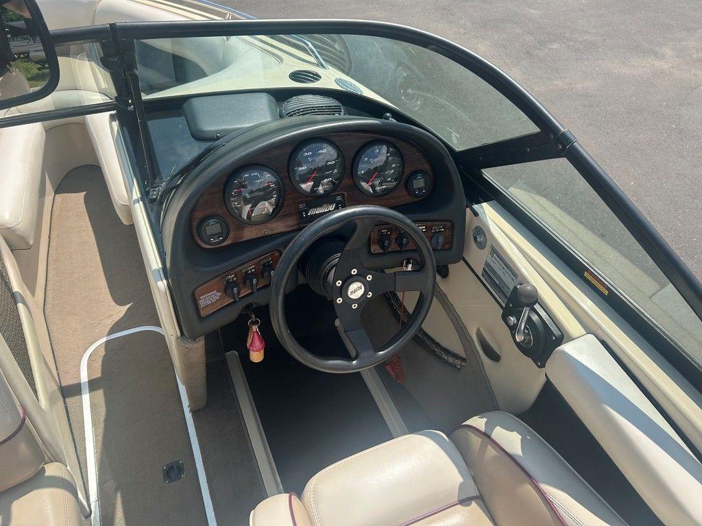 1999 Malibu Sunsetter VLX boat interior with steering wheel and dashboard gauges.