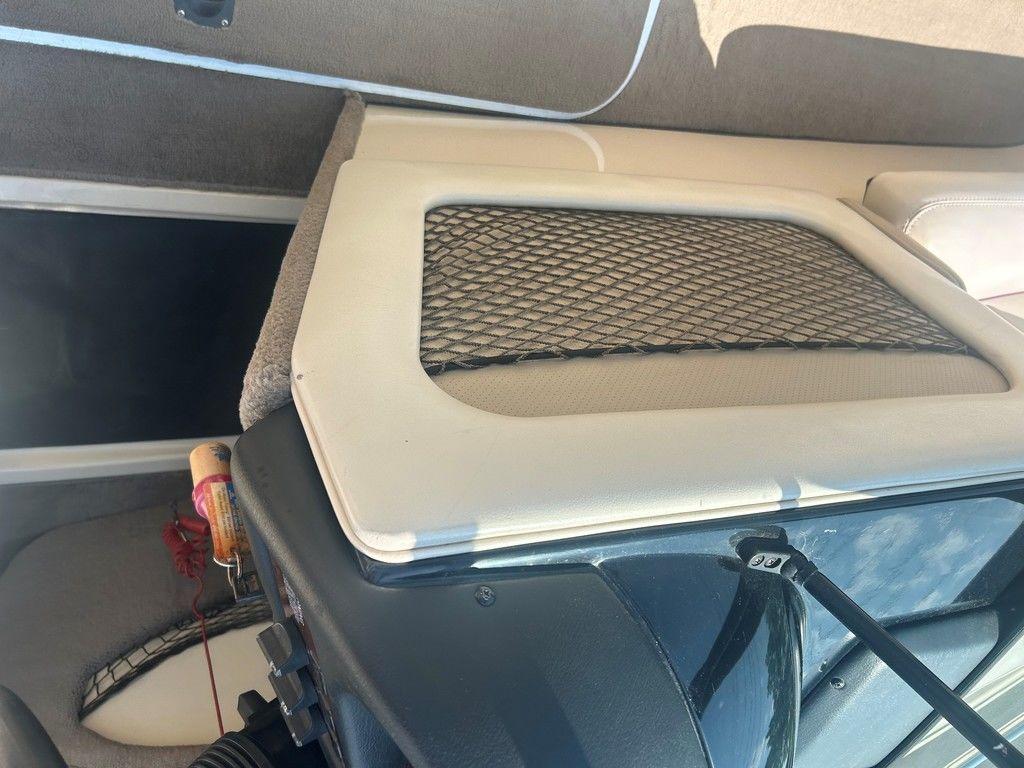 Interior of a 1999 Malibu Sunsetter VLX boat with storage compartment.