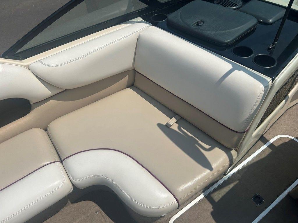 1999 Malibu Sunsetter VLX boat interior with beige seating and cup holders.