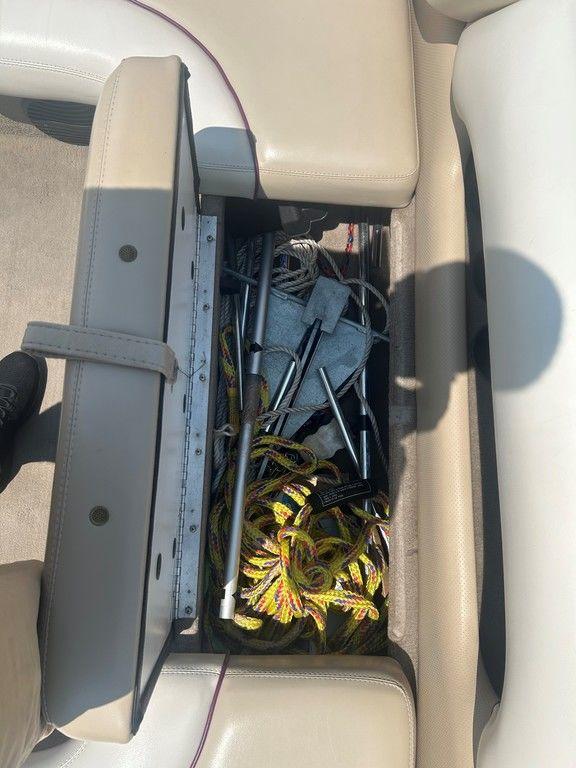 Storage compartment in a 1999 Malibu Sunsetter VLX boat, containing ropes and equipment.
