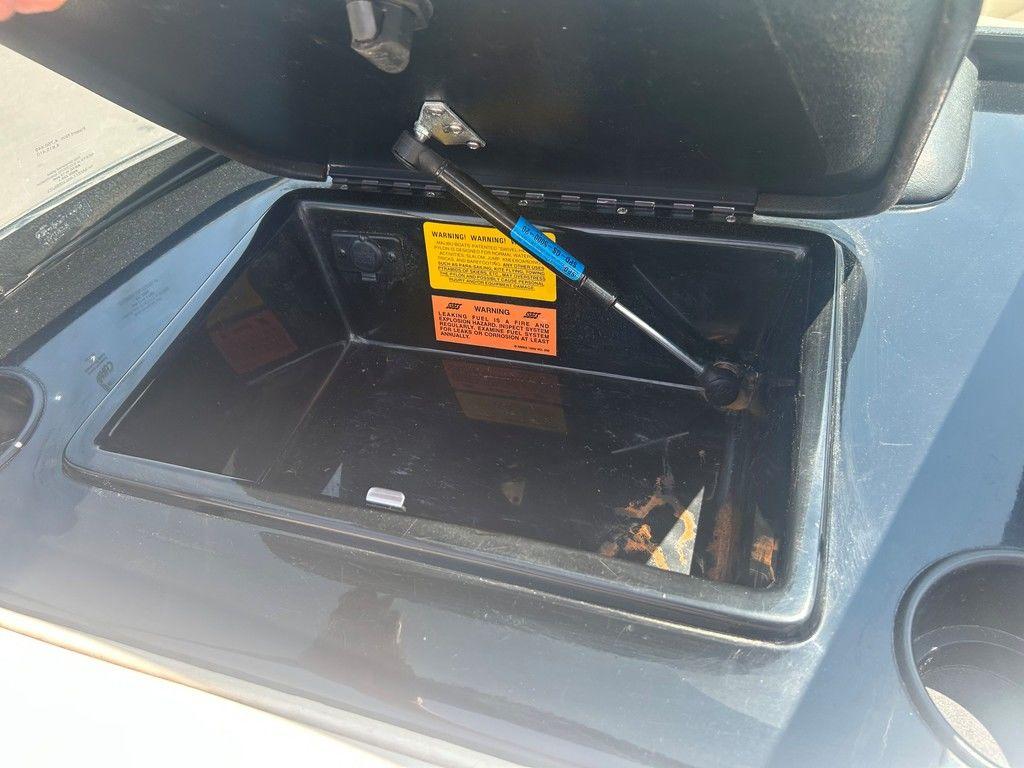 Open storage compartment in a 1999 Malibu Sunsetter VLX boat.