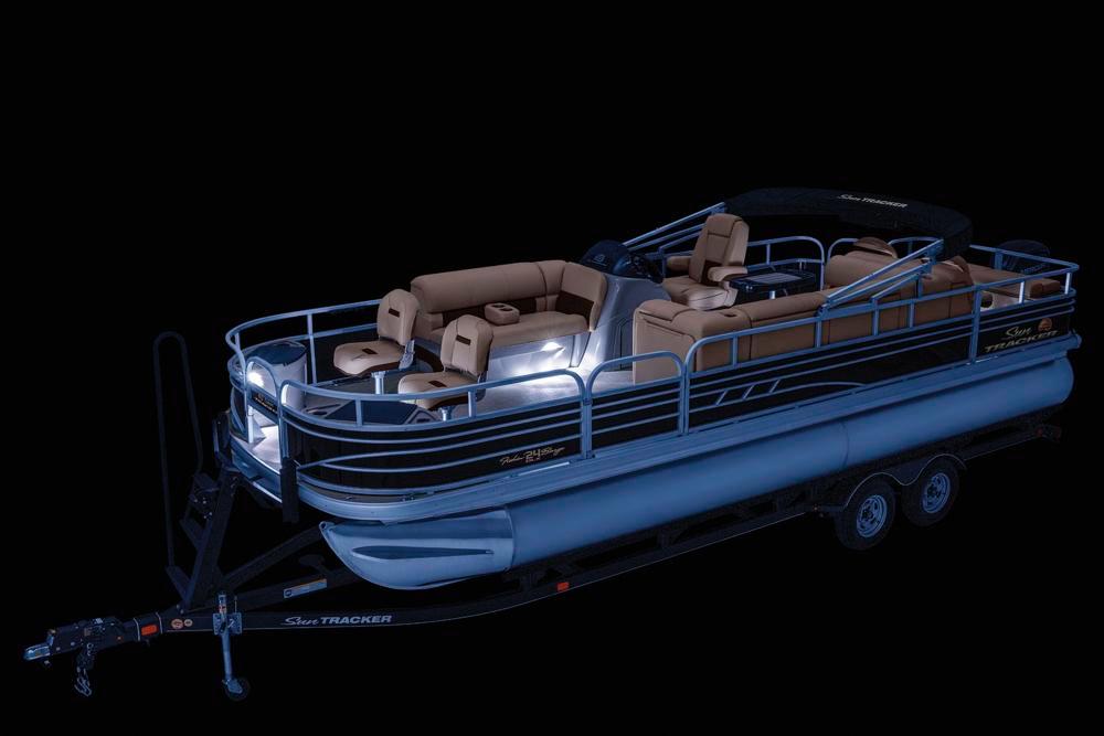 2021 Sun Tracker Fishin' Barge 24 DLX pontoon boat with illuminated interior on trailer.
