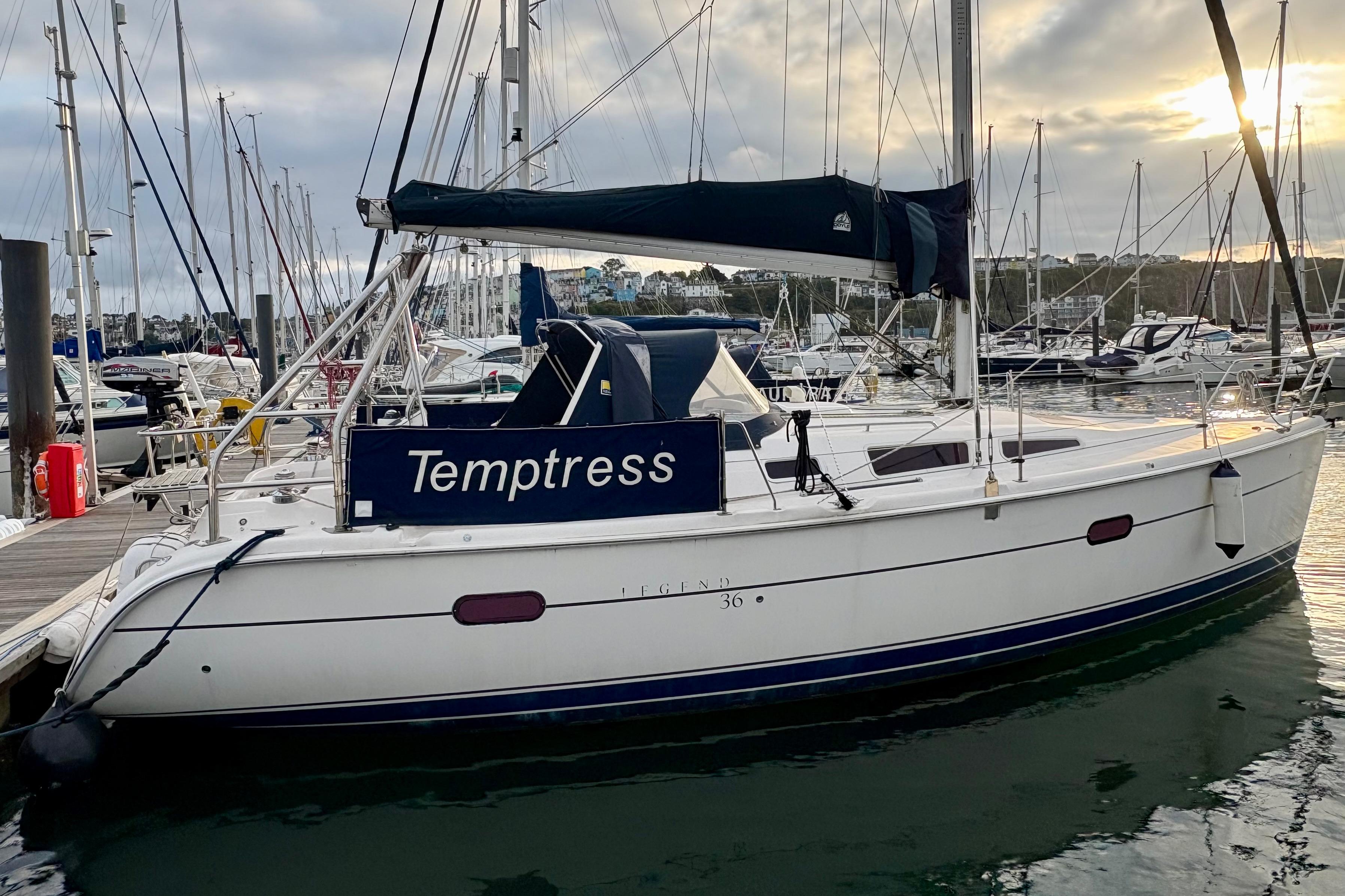 2004 Hunter Legend 36 sailboat docked at marina during sunset.