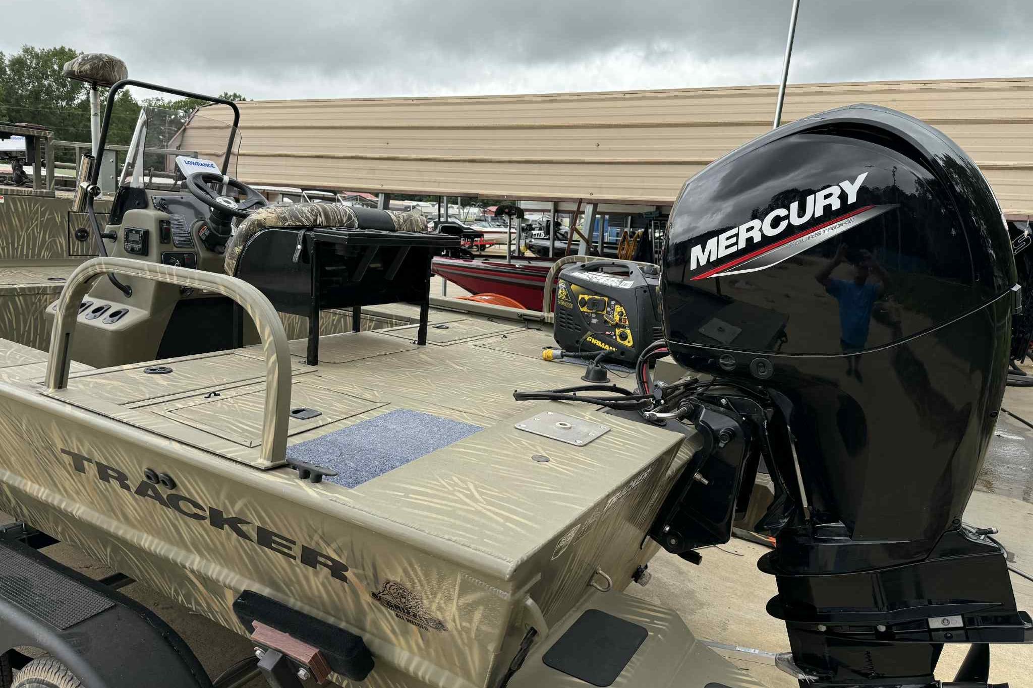 2022 Tracker Grizzly 2072 CC Sportsman boat with Mercury outboard motor, parked outdoors.