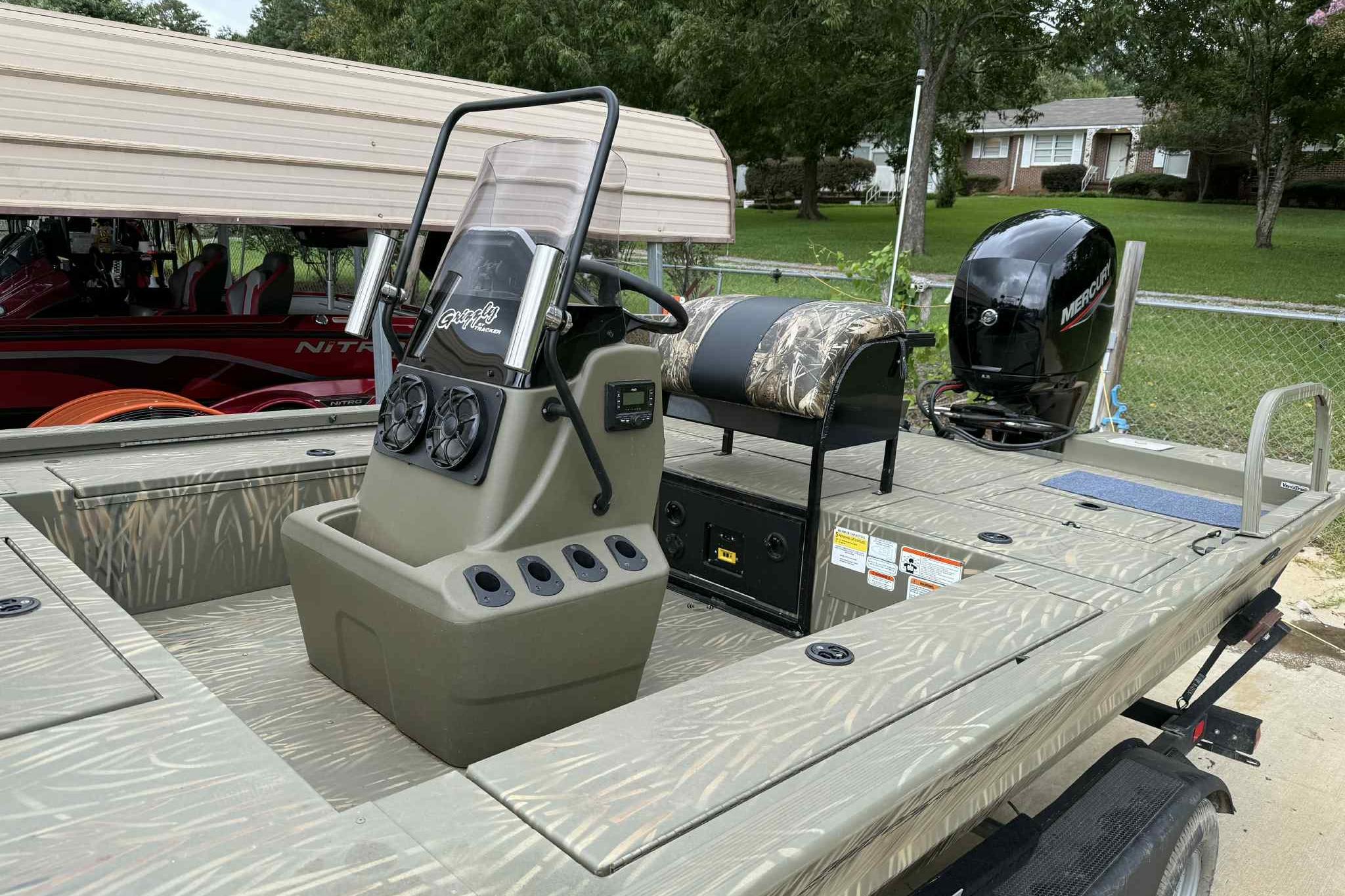 2022 Tracker Grizzly 2072 CC Sportsman boat with camo seating and Mercury outboard motor.