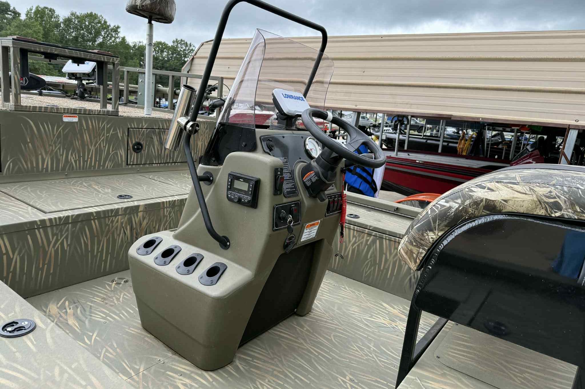 2022 Tracker Grizzly 2072 CC Sportsman boat interior with steering console and camouflage design.