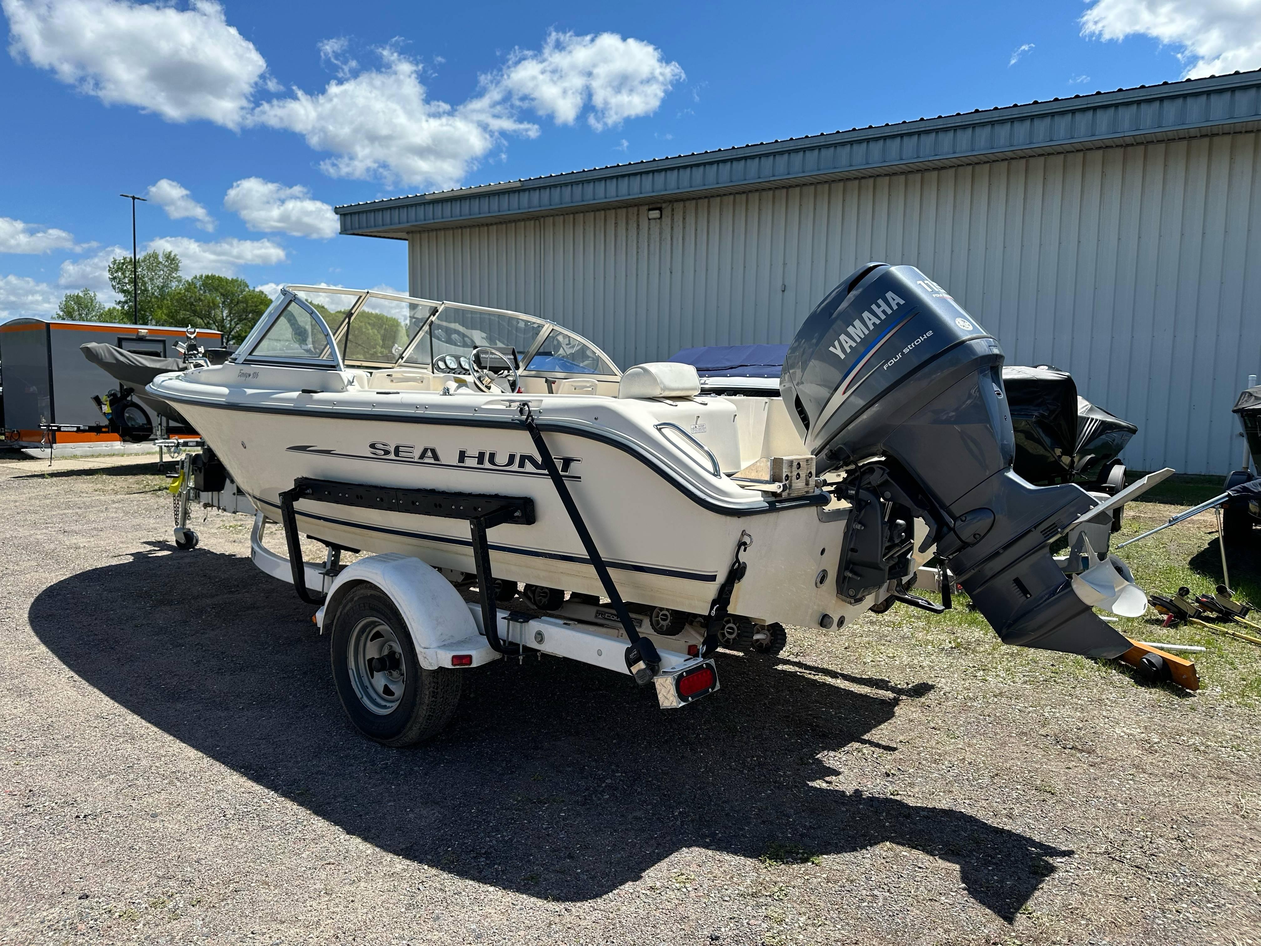 2003 Sea Hunt Escape 186 boat with Yamaha motor on trailer, parked outdoors.