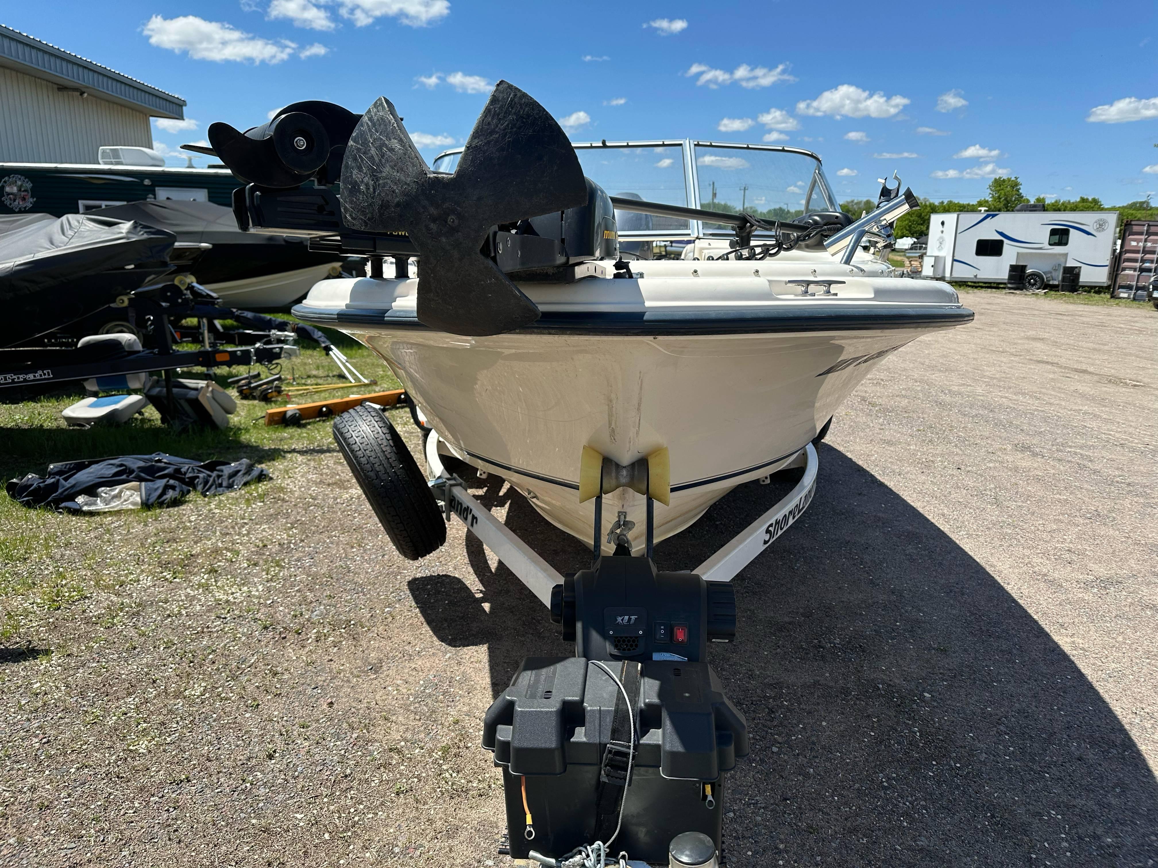 2003 Sea Hunt Escape 186 boat on trailer, parked outdoors under a clear blue sky.