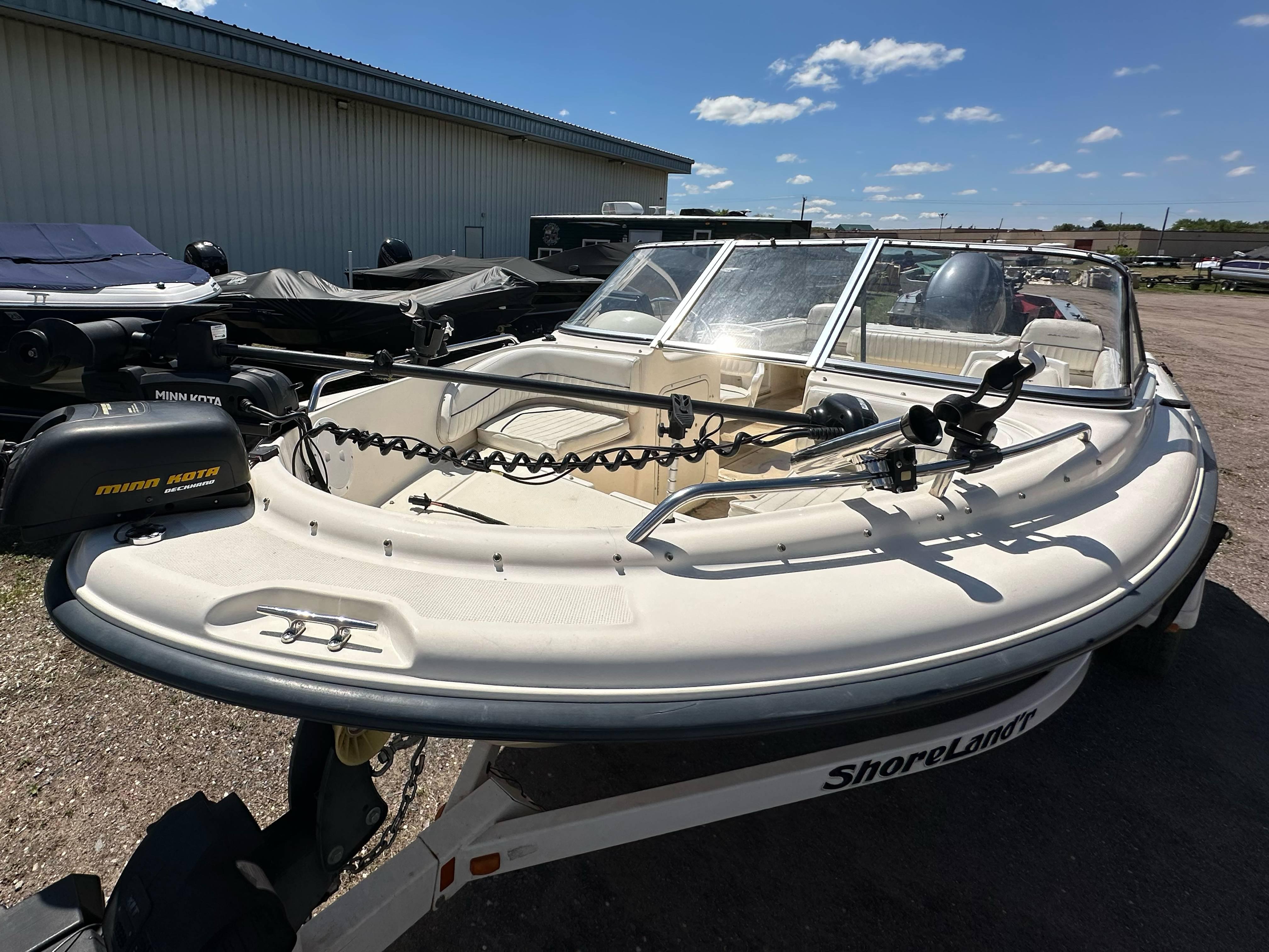 2003 Sea Hunt Escape 186 boat on ShoreLand'r trailer, parked outdoors under clear sky.