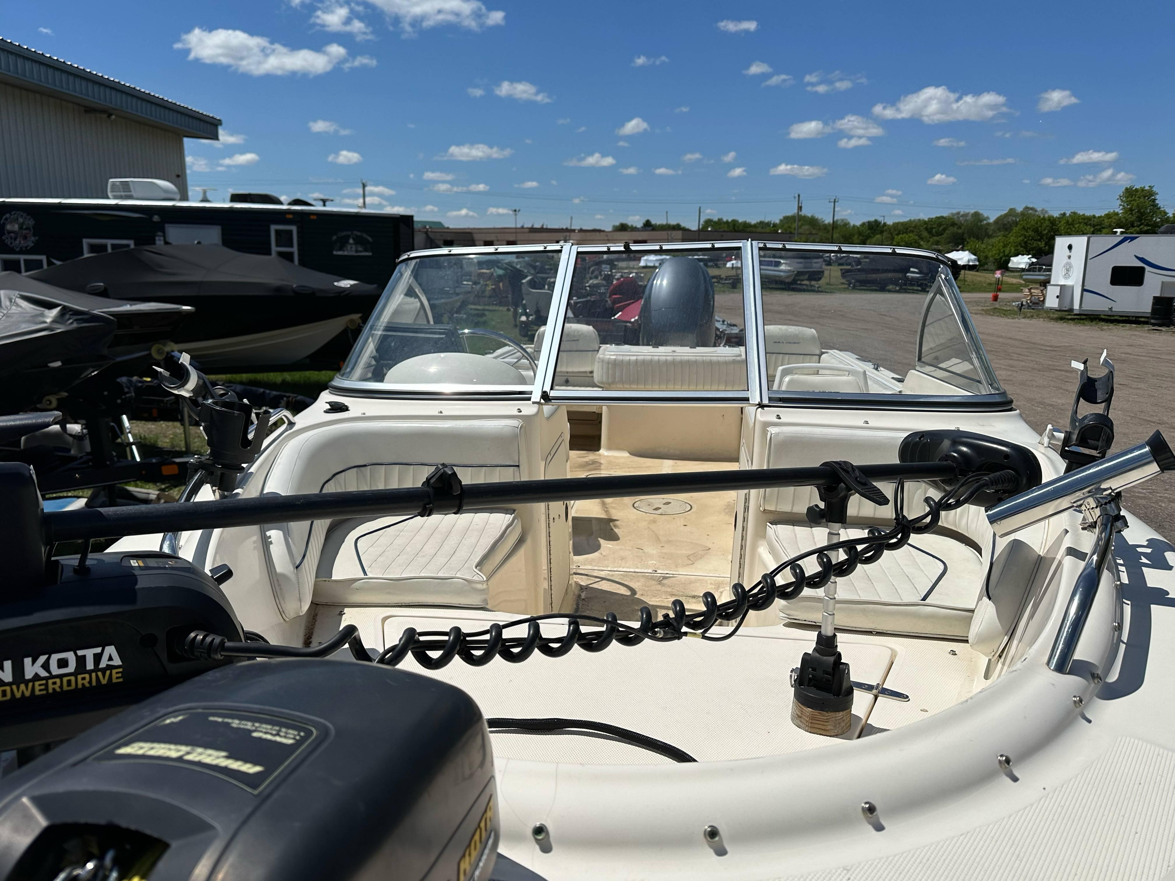 2003 Sea Hunt Escape 186 boat with open deck, parked outdoors under a clear sky.