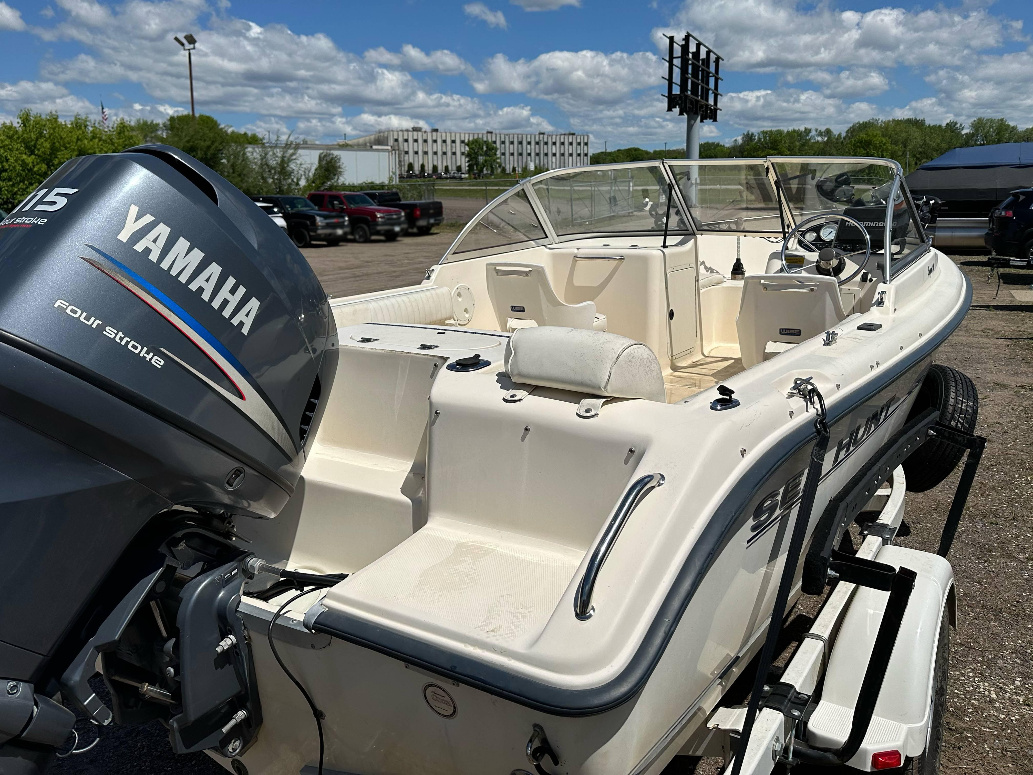 2003 Sea Hunt Escape 186 boat with Yamaha 115 engine, parked outdoors under a blue sky.