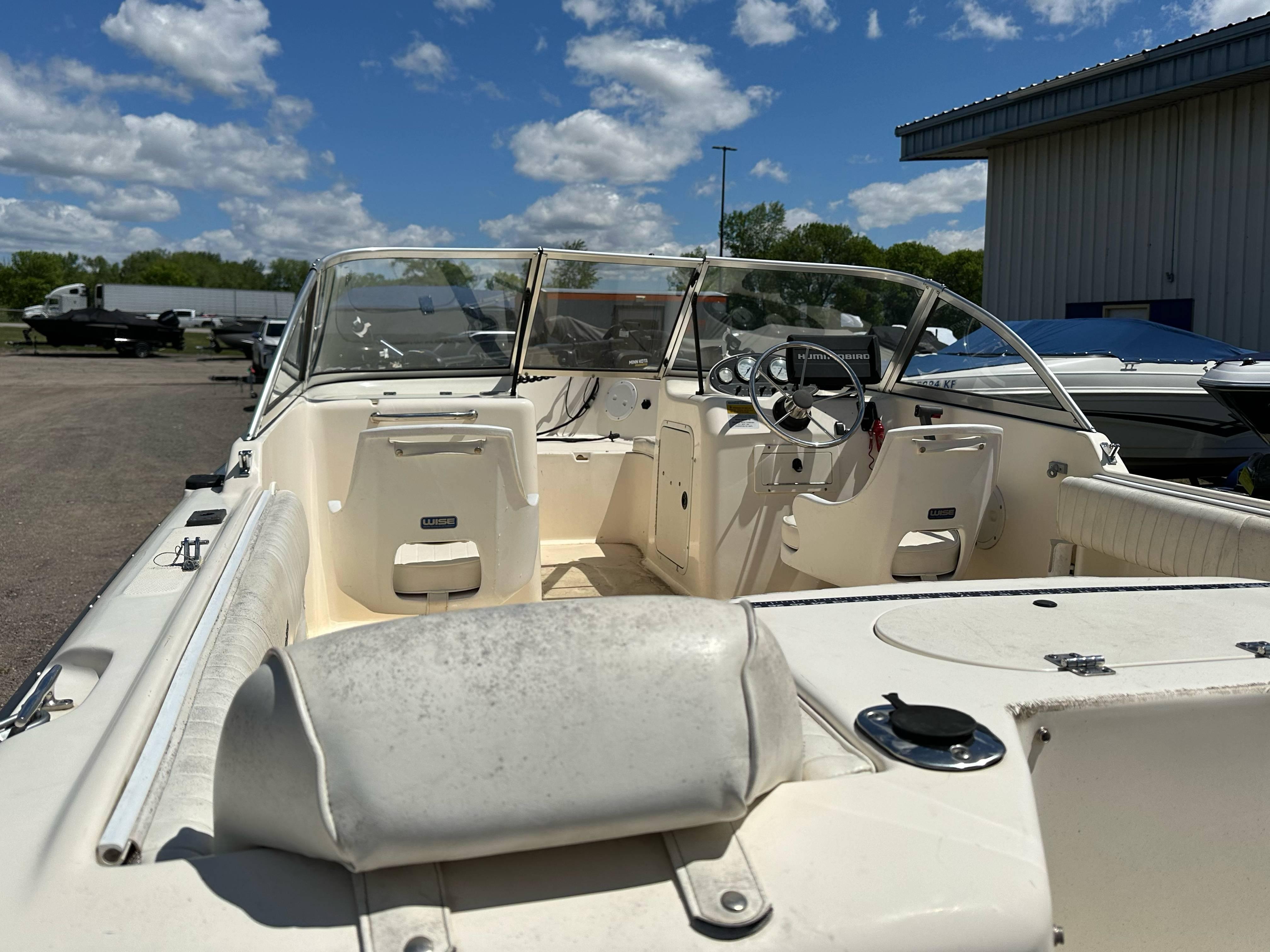 2003 Sea Hunt Escape 186 boat with open deck, parked outdoors under a blue sky.