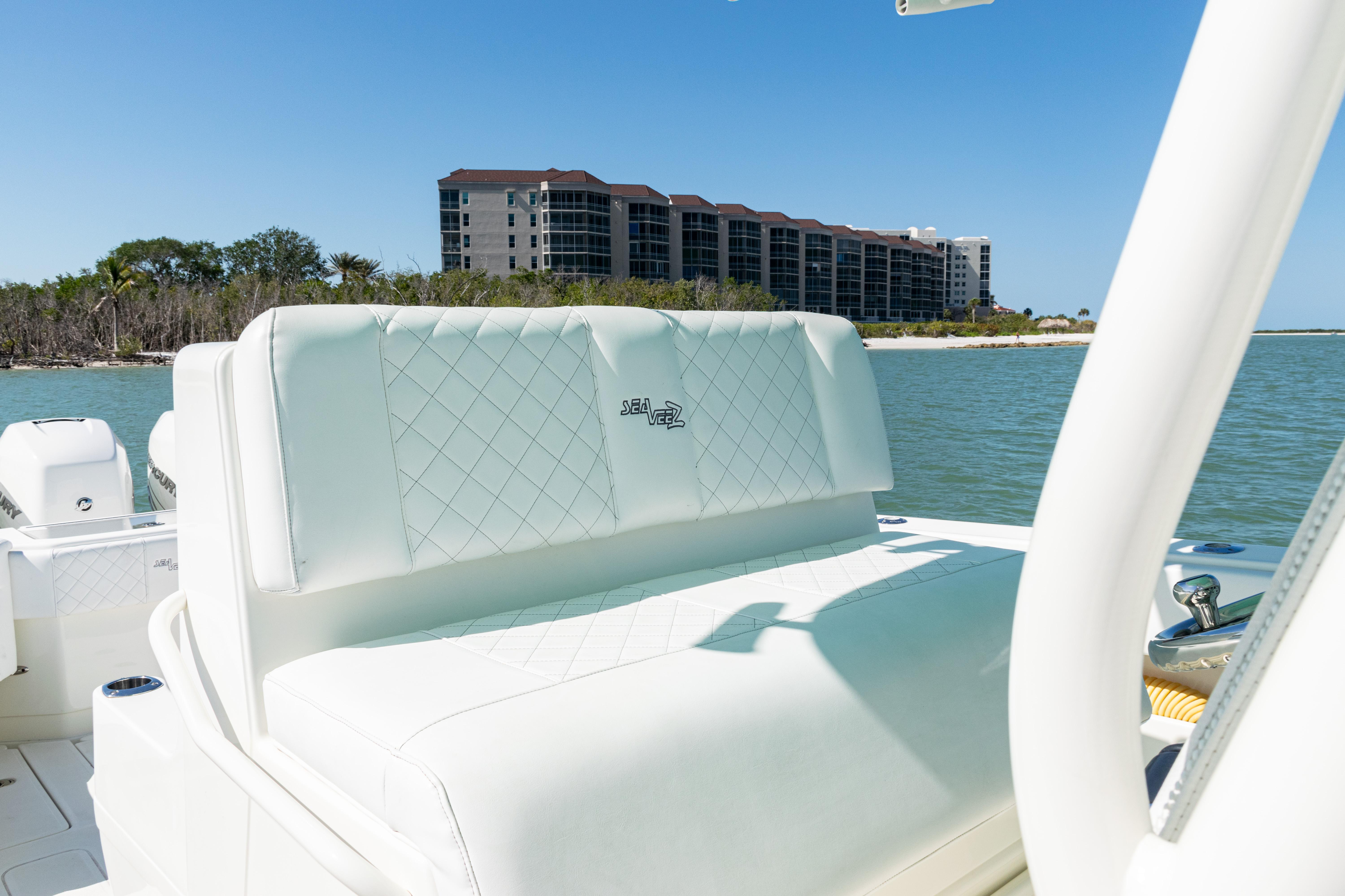 SeaVee-390Z 2015 -FL-US-2015 SeaVee 390Z boat interior with white seating, coastal view, and modern buildings in the background.-9766060 | Thumbnail