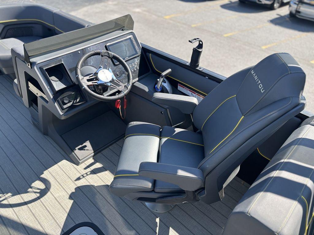 2023 Manitou Explore 22 Max Bench boat interior with steering wheel and captain's chair.
