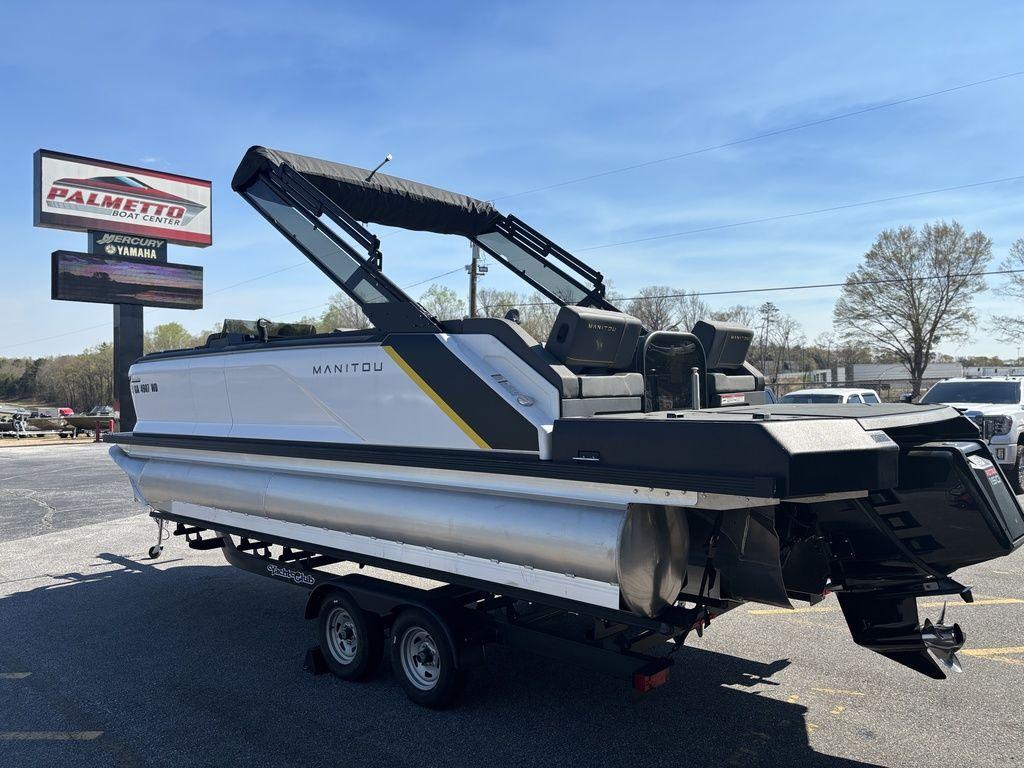 2023 Manitou Explore 22 Max Bench pontoon boat on trailer at dealership.