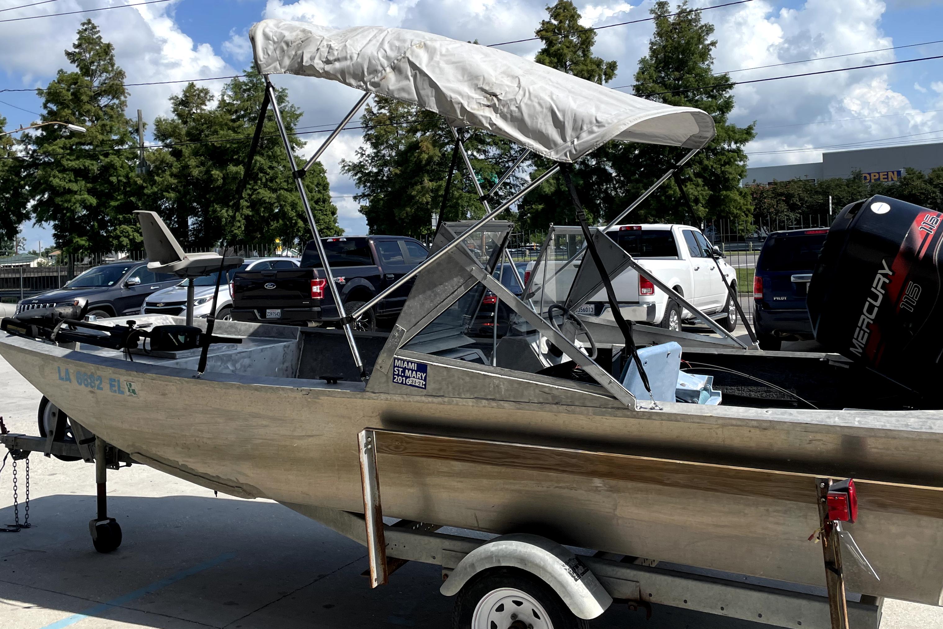 Custom Aluminum 15 boat, 1994 model, with canopy and trailer, parked outdoors.