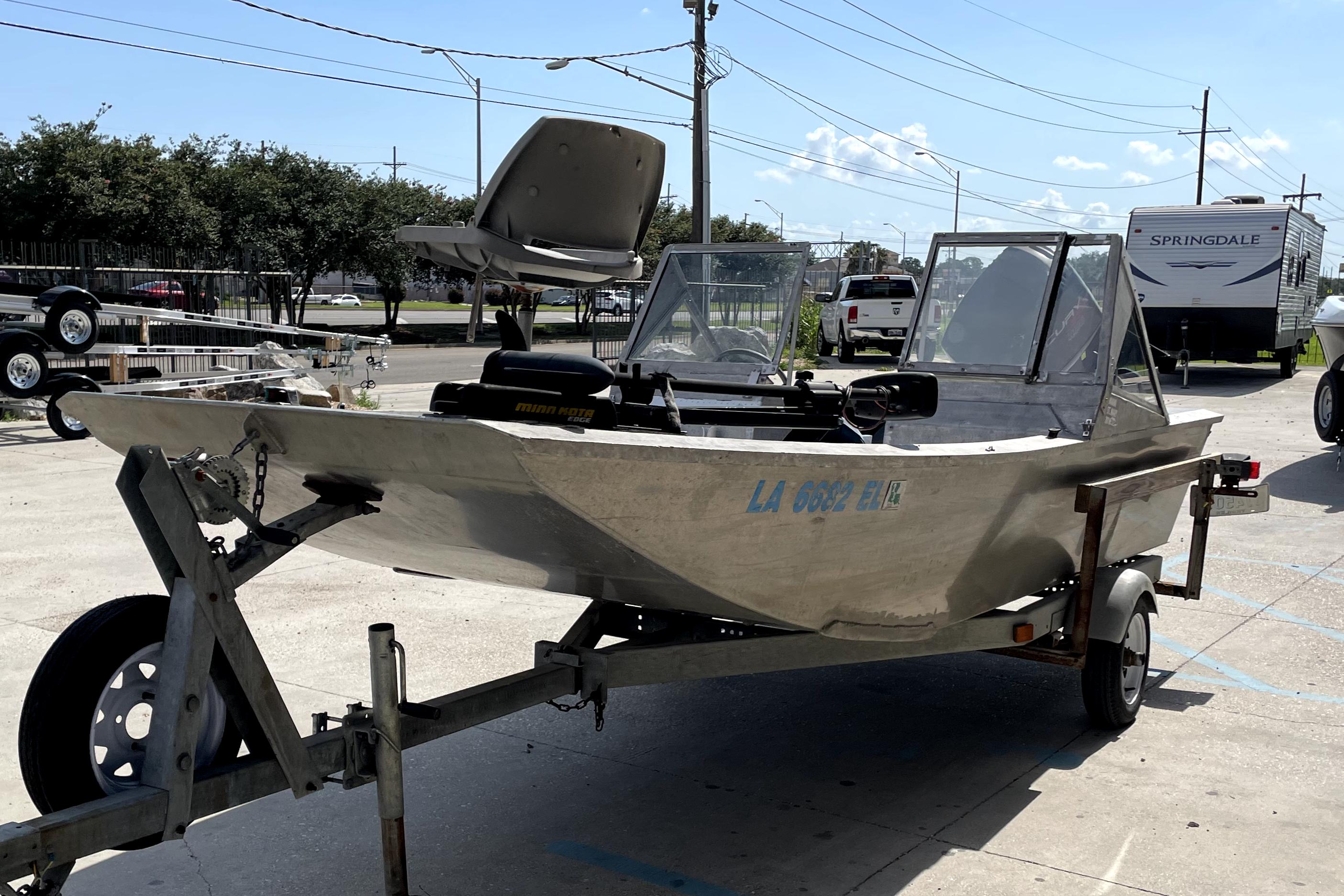 Custom Aluminum 15 boat on trailer, 1994 model, parked outdoors under clear sky.