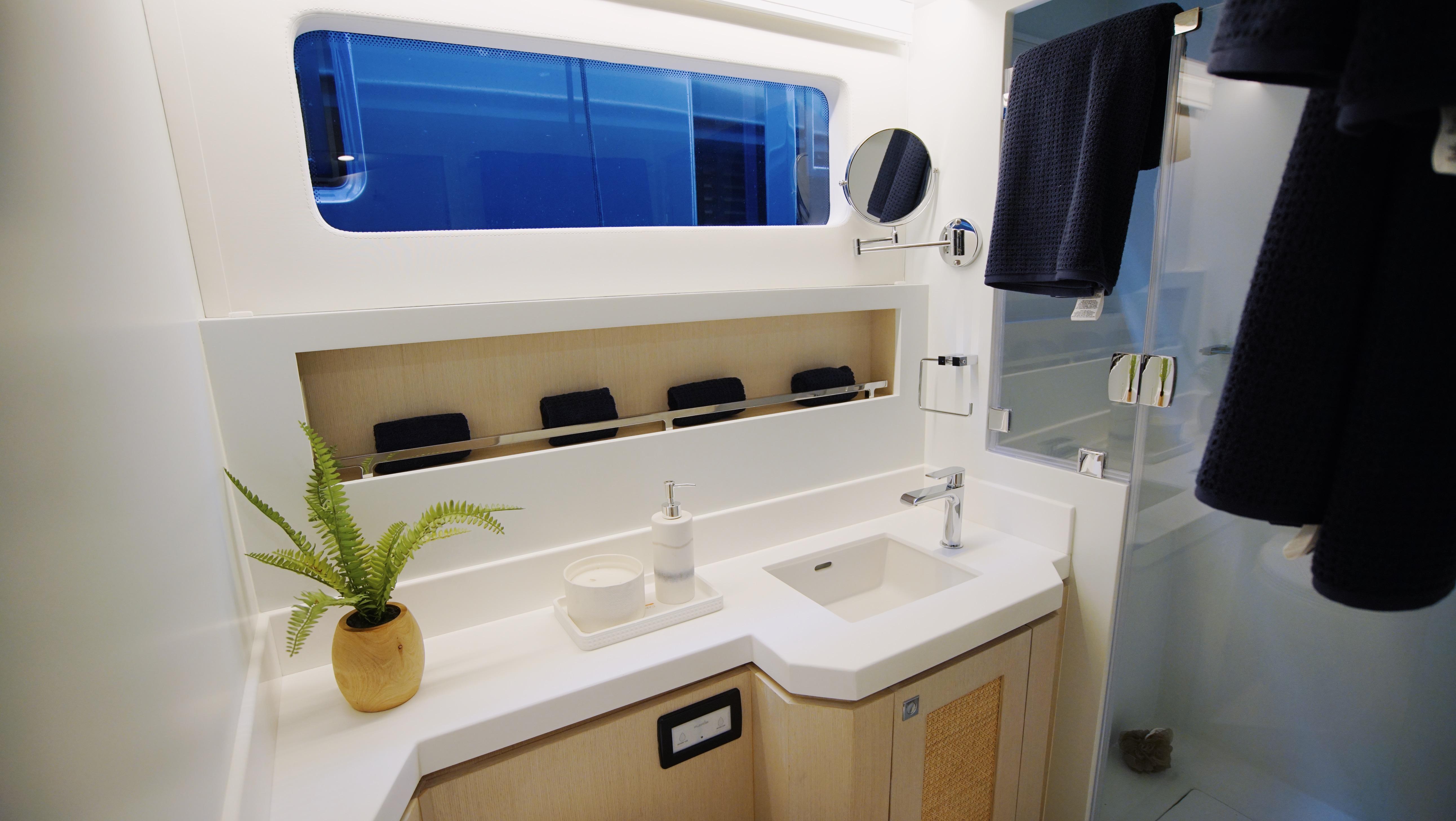Two Oceans-555  008 2025 -FL-US-Modern yacht bathroom with sleek design, featuring a sink, mirror, and potted plant. Two Oceans 555  008.-9676126 | Thumbnail