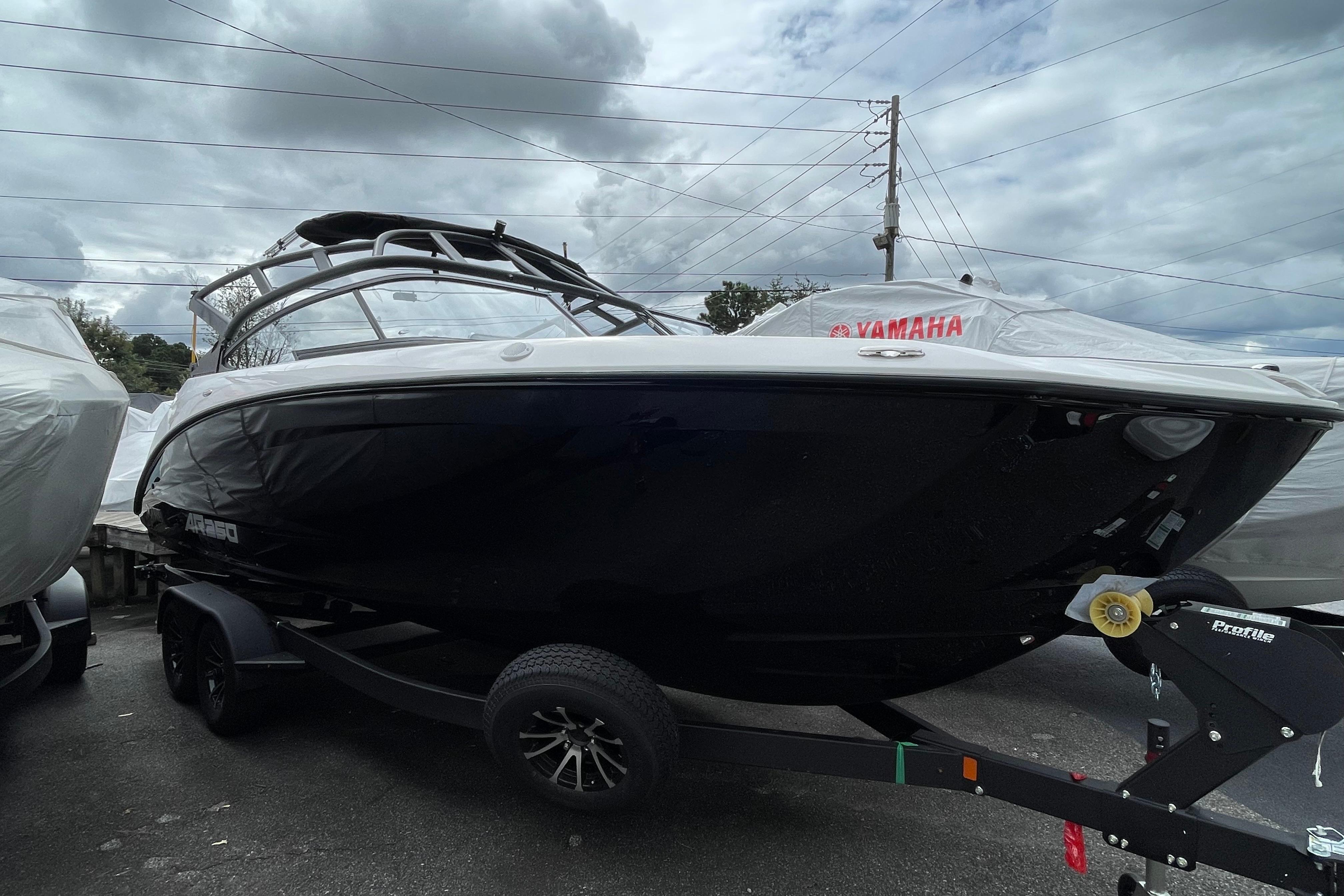 2026 Yamaha AR250 boat on trailer under cloudy sky.