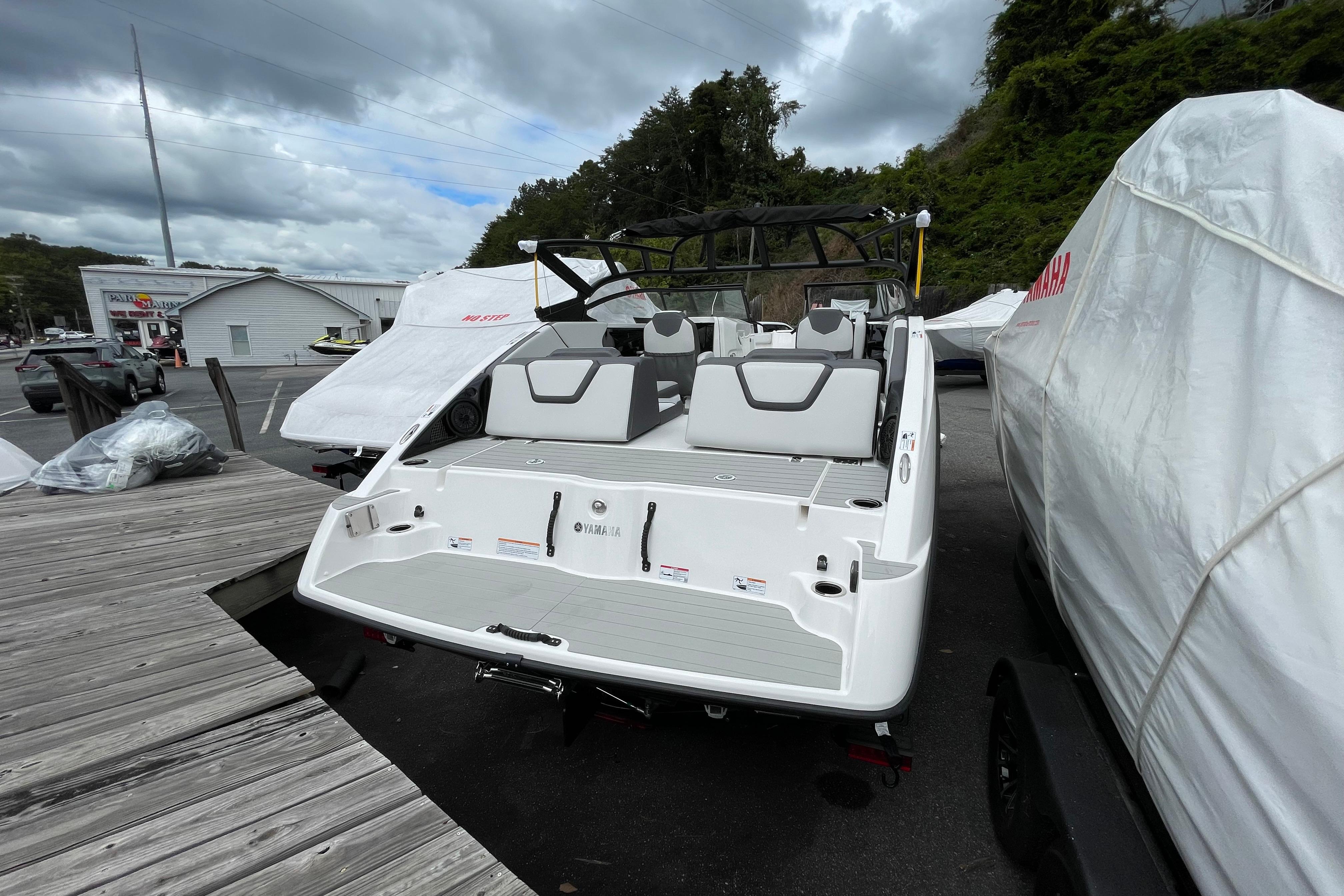 2026 Yamaha AR250 boat docked, rear view, with covered boats nearby.