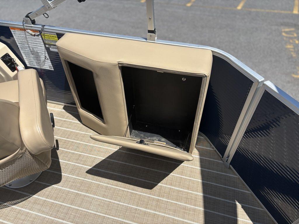 Open storage compartment on a 2021 Godfrey SW 2086 C boat, featuring beige upholstery.