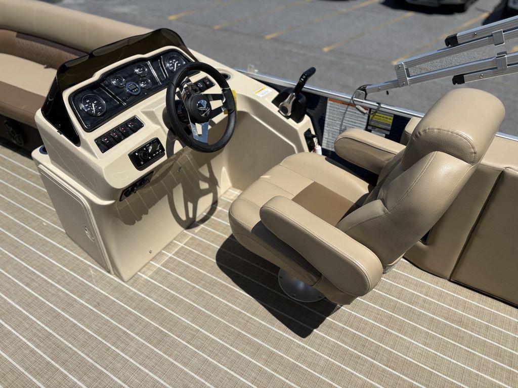 Captain's seat and helm of 2021 Godfrey SW 2086 C boat, featuring beige upholstery and controls.