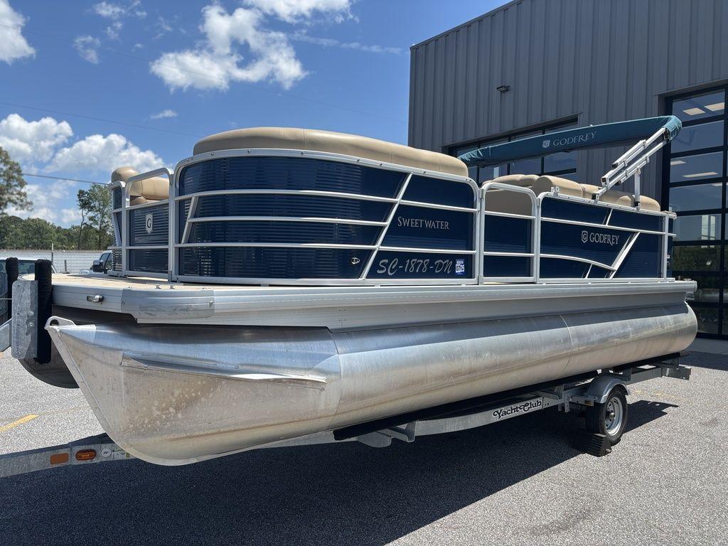 2021 Godfrey SW 2086 C pontoon boat on trailer, parked outdoors under blue sky.