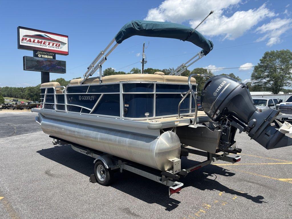 2021 Godfrey SW 2086 C pontoon boat on trailer, parked outdoors under blue sky.