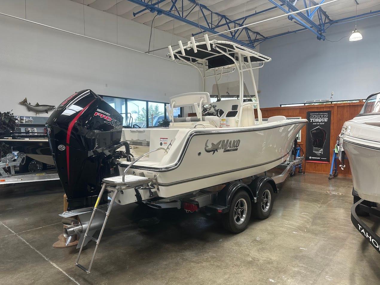2025 Mako 214 CC boat with Mercury engine displayed indoors on a trailer.