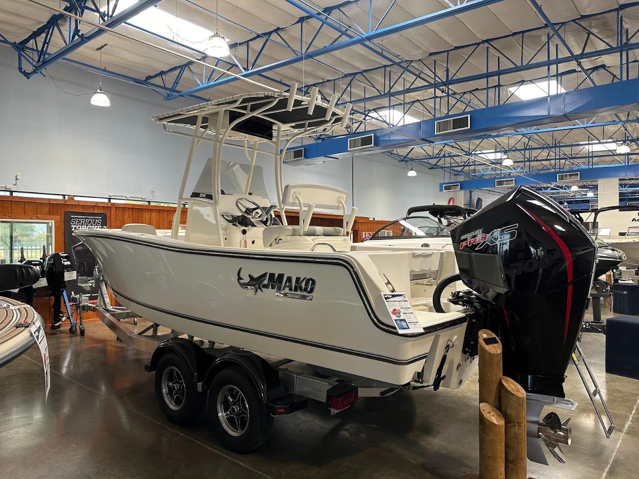2025 Mako 214 CC boat displayed indoors with Mercury engine.