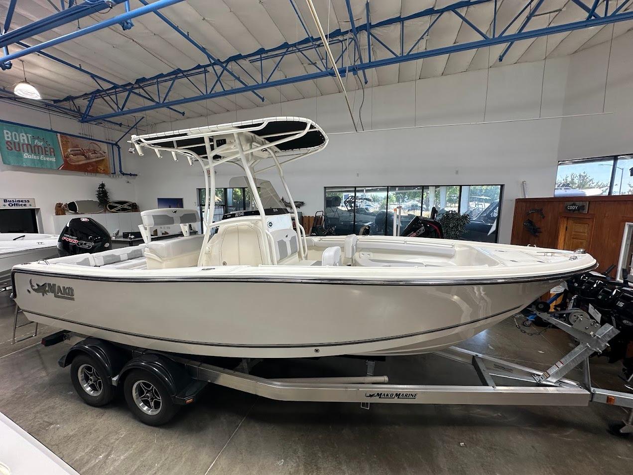 2025 Mako 214 CC boat on trailer in showroom, featuring sleek design and modern amenities.