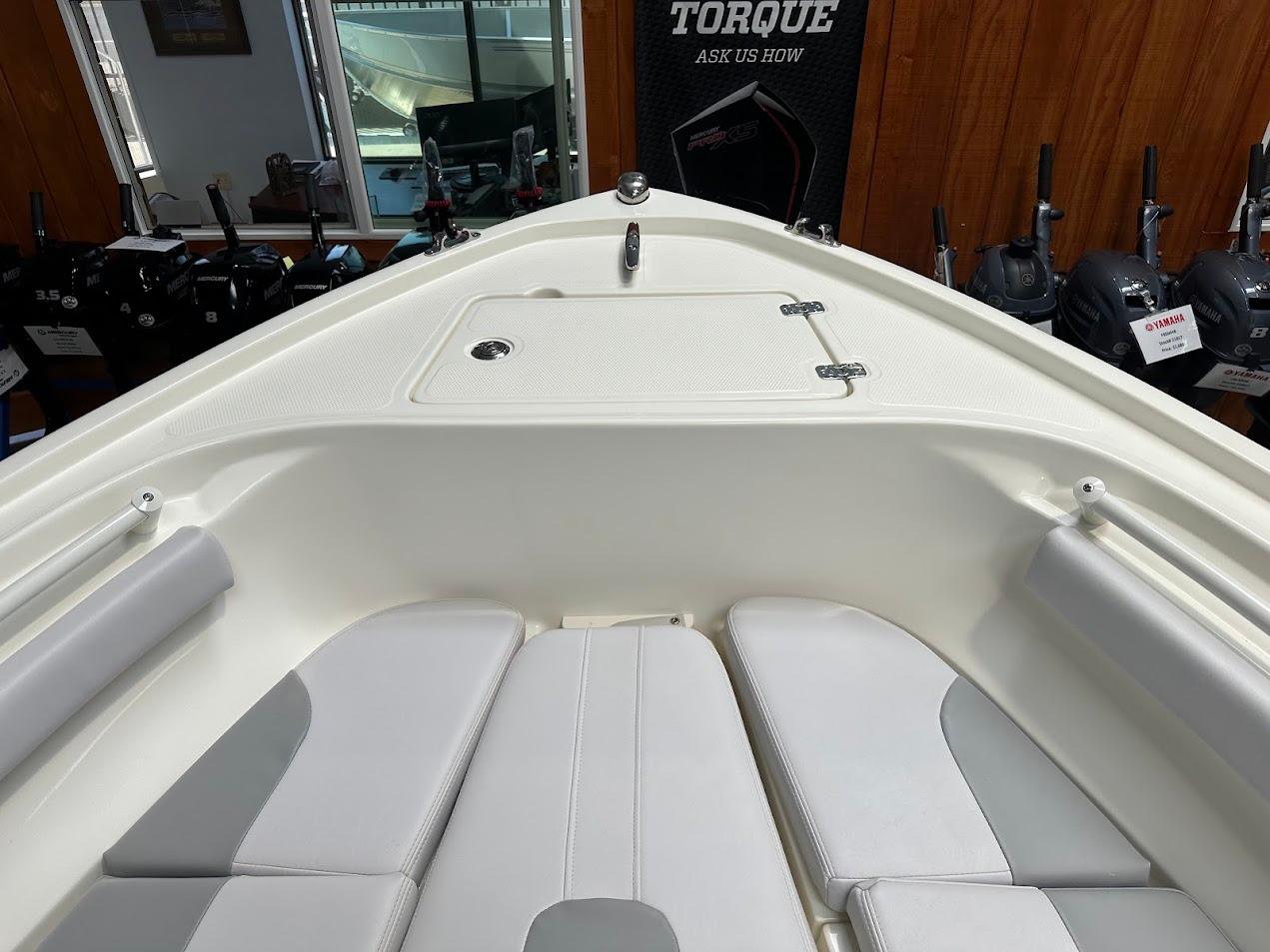 2025 Mako 214 CC boat interior with cushioned seating and storage compartment.