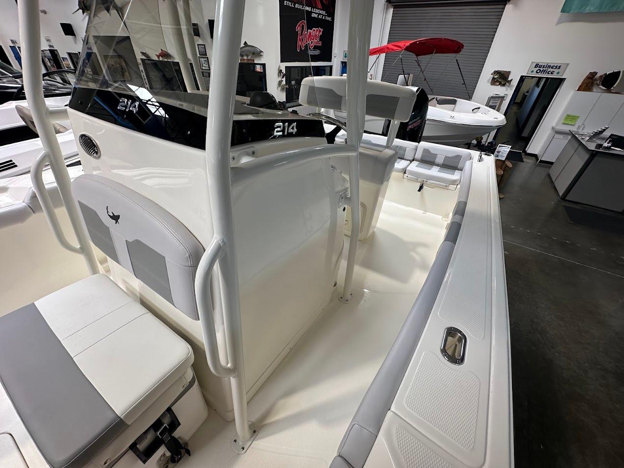 2025 Mako 214 CC boat interior with seating and console, displayed in showroom.