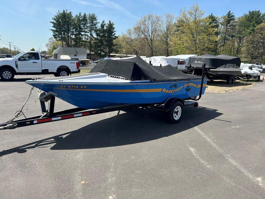 1980 Ski Supreme boat on trailer, blue with cover, parked outdoors.