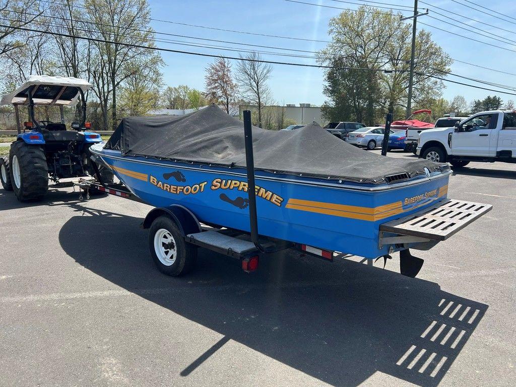 1980 Ski Supreme boat with cover, on trailer, parked outdoors.