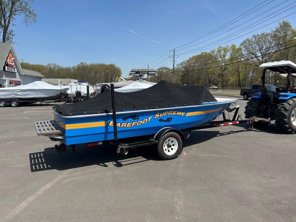 1980 Ski Supreme boat on trailer, covered, parked outdoors.