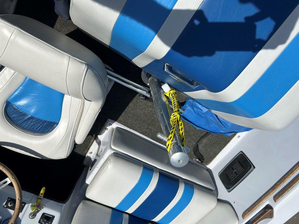 1980 Ski Supreme boat interior with blue and white seats, yellow rope, and wooden accents.