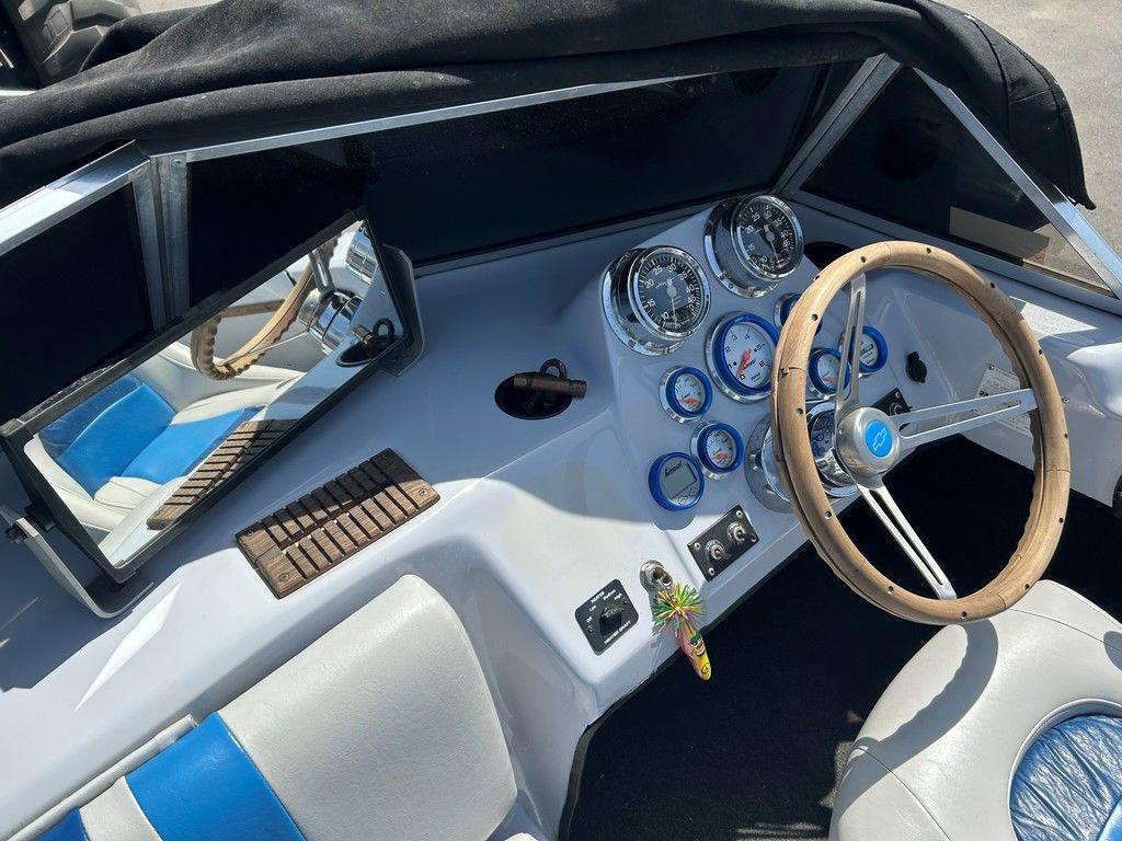 1980 Ski Supreme boat dashboard with gauges, wooden steering wheel, and blue-accented seats.