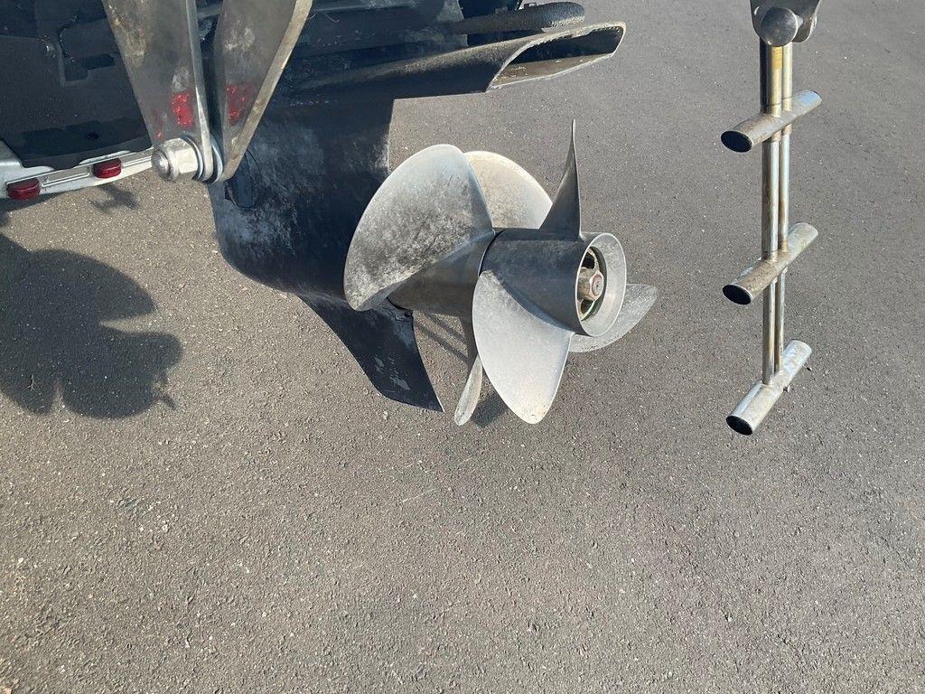 Propeller of a 2013 Cobalt 210 boat on a paved surface.