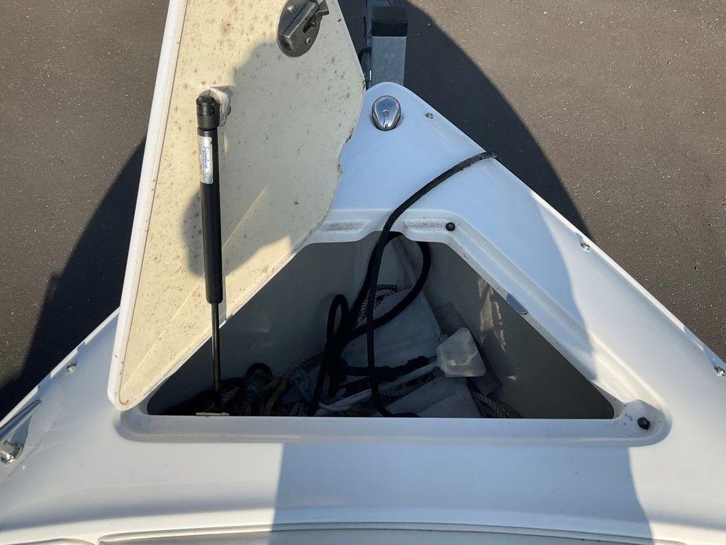 Open storage compartment on a 2013 Cobalt 210 boat, showing ropes and equipment.