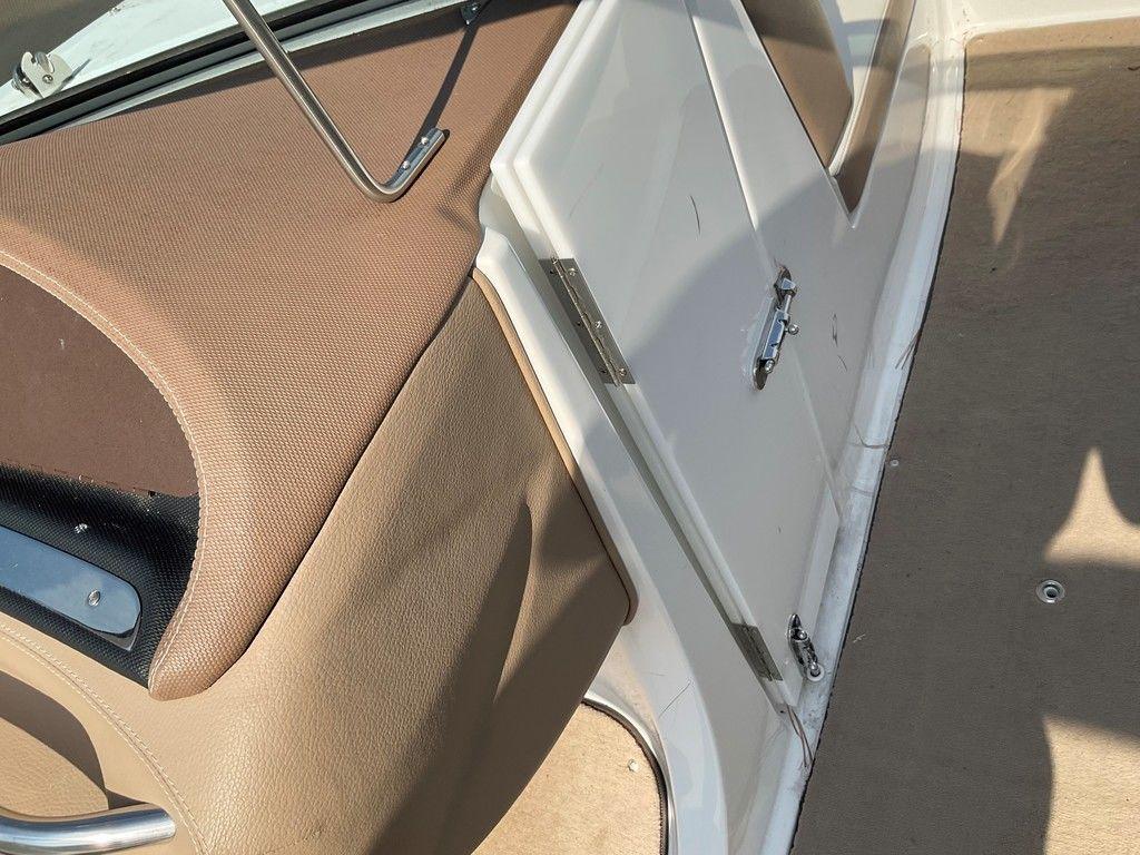 Interior of a 2013 Cobalt 210 boat, featuring beige upholstery and a white storage compartment.